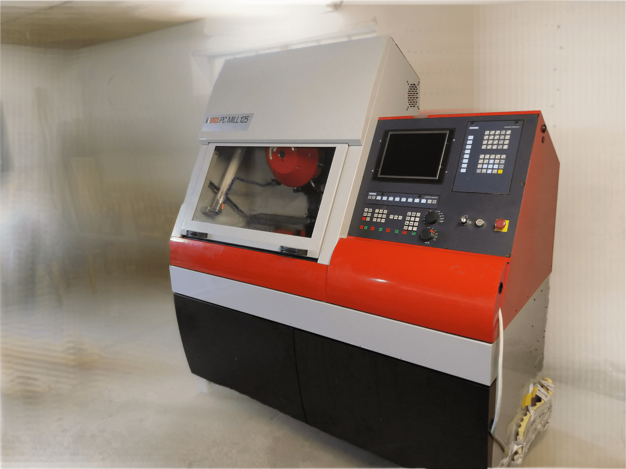 Vertikalni obradni centar EMCO PC MILL 125, prednji pogled s upravljačkom pločom i vidljivim područjem obrade.