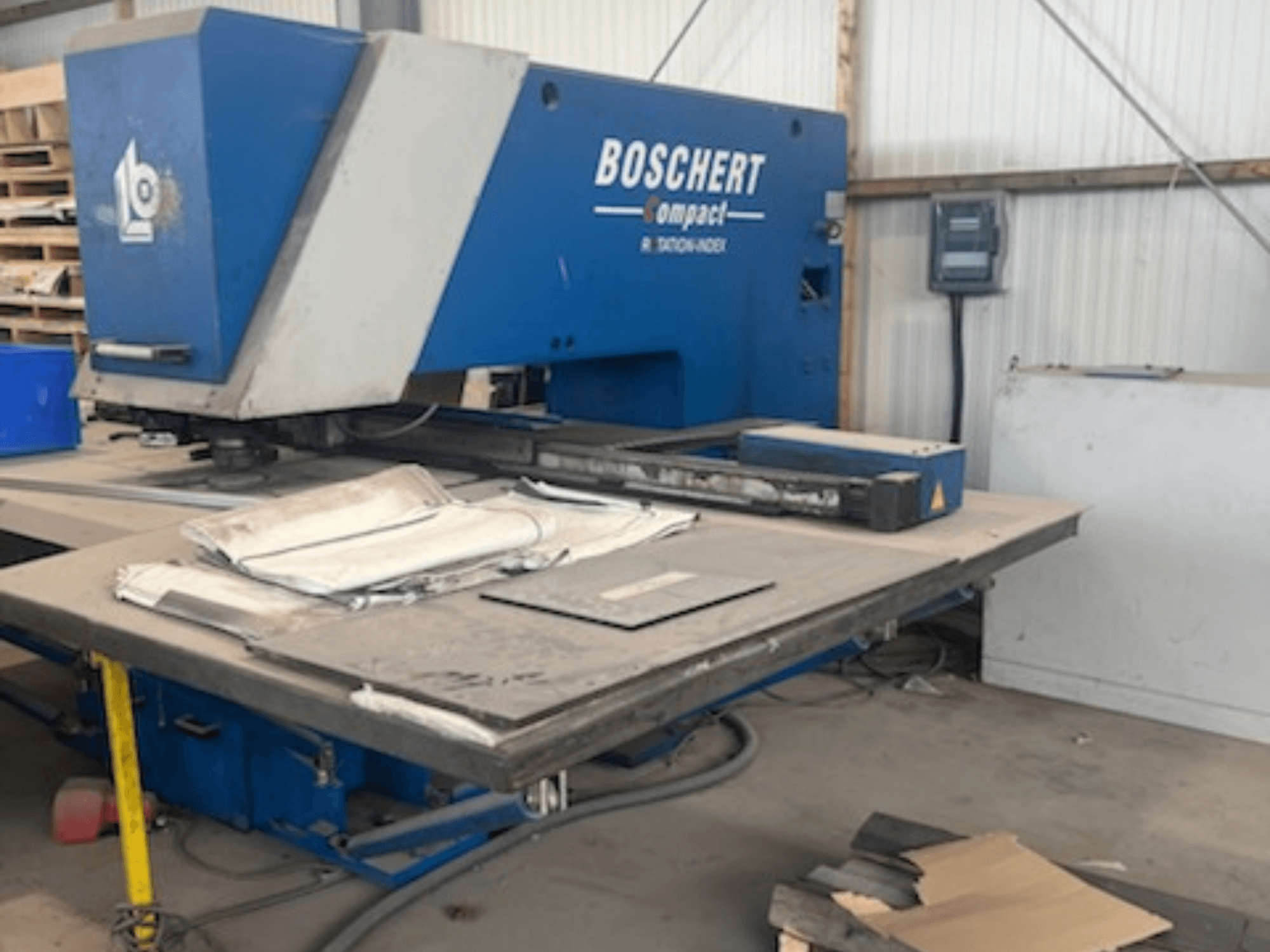 CNC probijajući stroj BOSCHERT COMPACT 1000 u radionici, s prednjim pogledom na metalne limove na stolu.