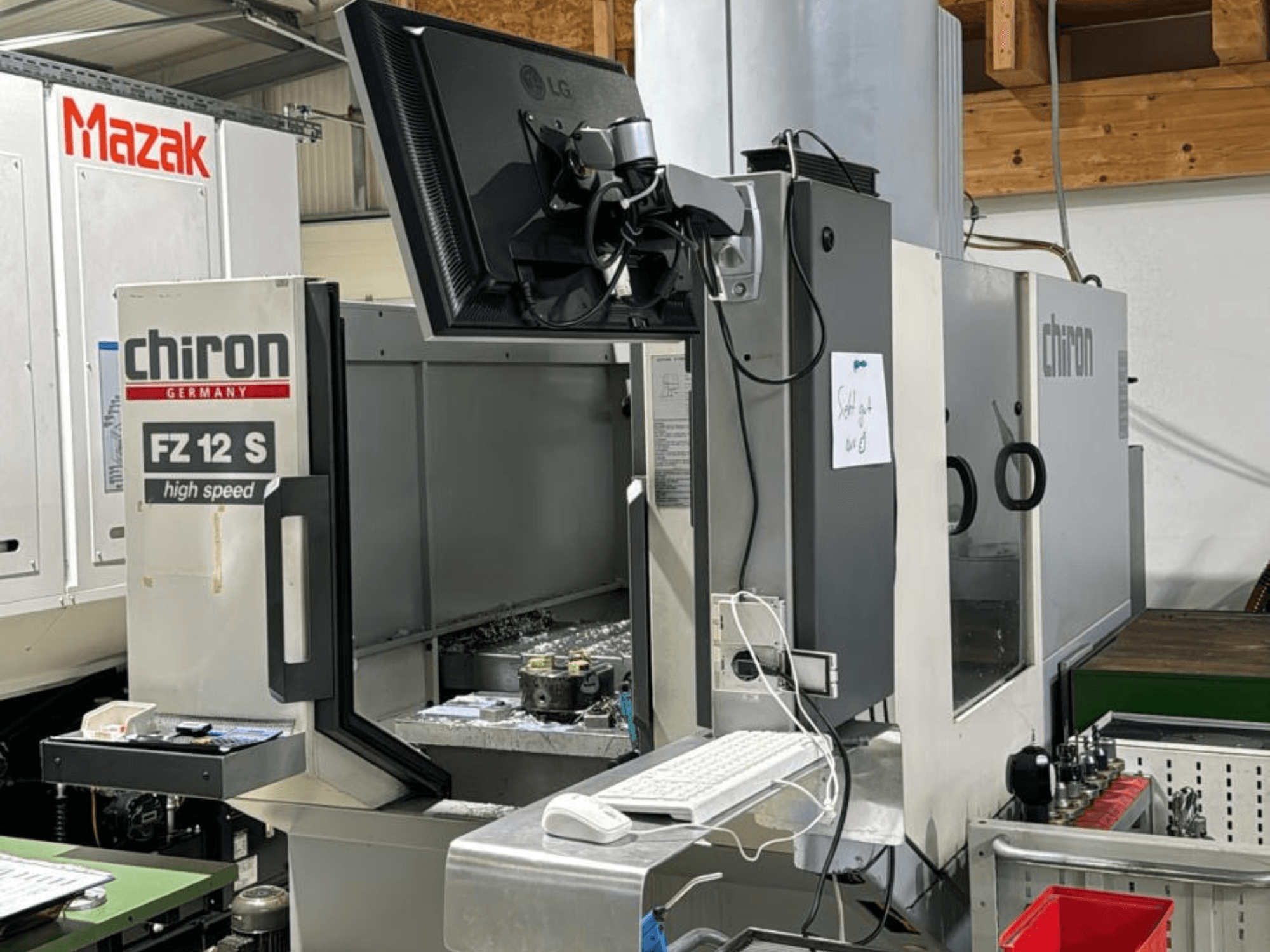 Vertikalni pogled na visokobrzinski obradni centar CHIRON FZ 12 S s kontrolnim zaslonom i ostacima iz procesa obrade.