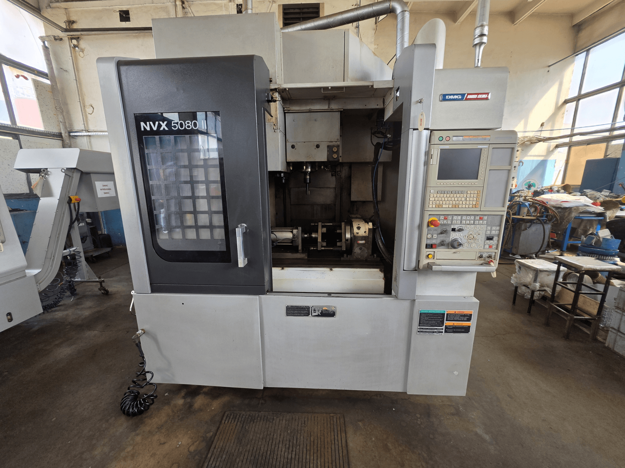 Prednji pogled na vertikalni obradni centar DMG Mori Seiki NVX 5080 II/40 s upravljačkom pločom i prozirnim prozorom, koji prikazuje područje obrade.