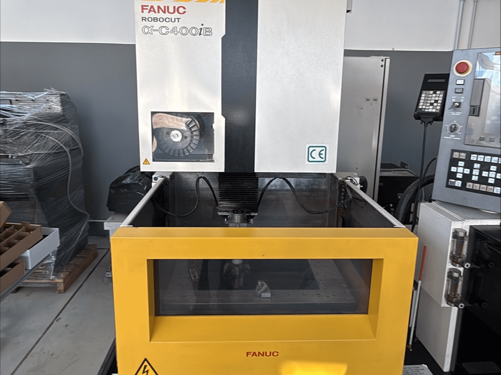 FANUC Robocut α-C400iB Stroj za žičanu eroziju, pogled sprijeda, sa žutim spremnikom i upravljačkom pločom.
