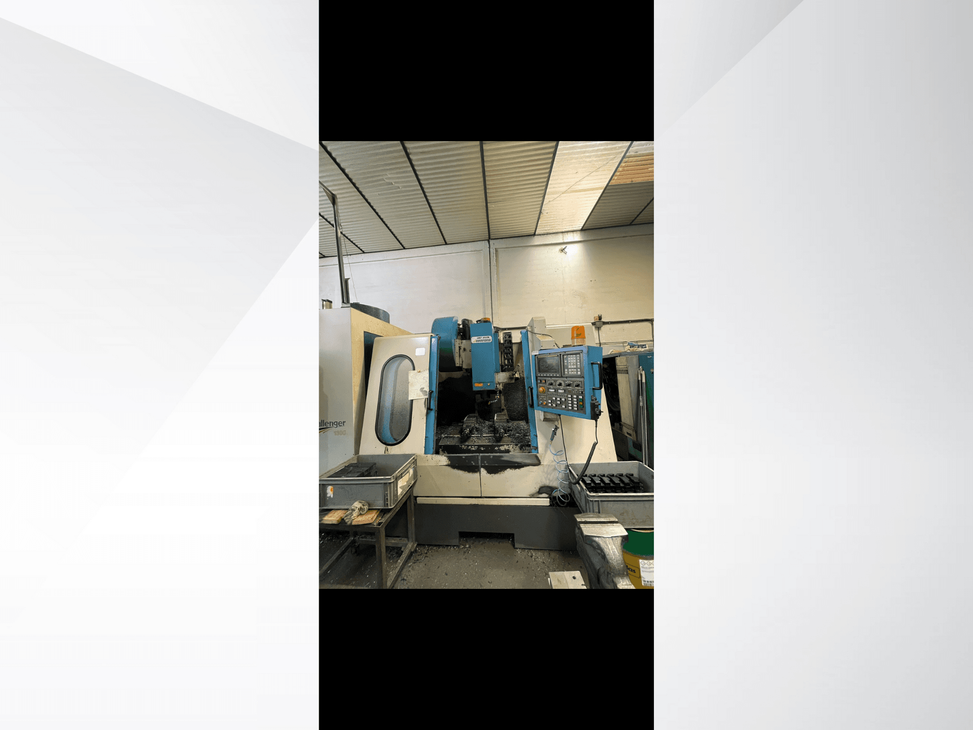 CNC stroj, model Challenger 1500, bočni pogled koji prikazuje upravljačku ploču i radni prostor s metalnim strugotinama.