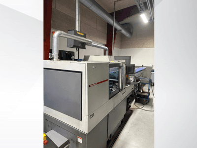 Industrijski strojevi marke MVC, bočni pogled s vidljivom upravljačkom pločom i kanalima, smješteni u tvorničkom okruženju.