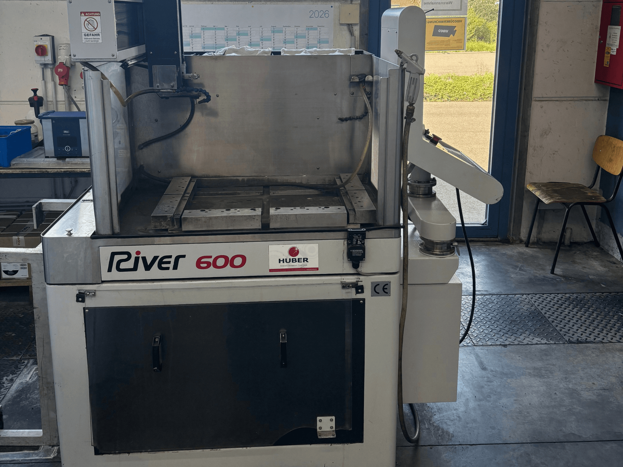 HUBER River 600 CNC stroj za erozijsku obradu, prednji pogled, s djelomično otvorenom radnom komorom i upravljačkom pločom.