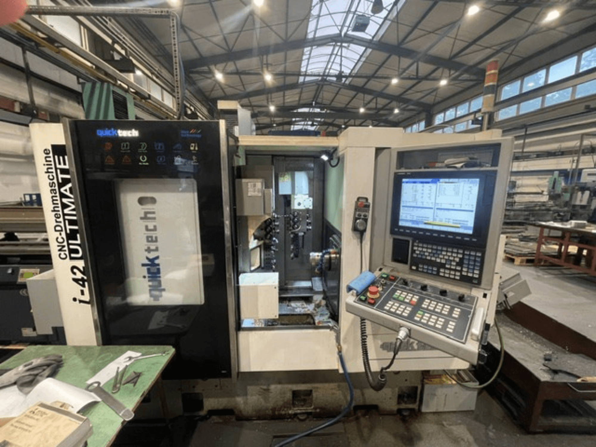 Quick-Tech I-42U tokarski stroj švicarskog tipa, pogled sprijeda, prikaz upravljačke ploče i CNC sučelja u radioničkom okruženju.
