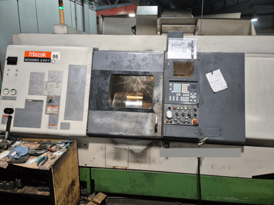 Mazak Integrex 200Y tokarski stroj, pogled sprijeda, s upravljačkom pločom i alatima na radnom stolu. Vidljivi mjerači i zaslon.