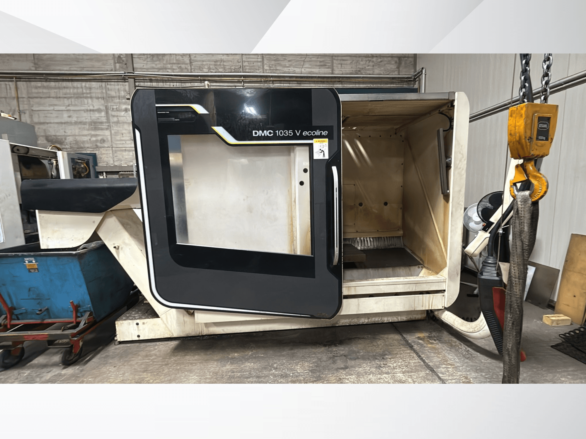 DMC 1035 V ecoline CNC stroj, prednji pogled, ima otvorena vrata koja otkrivaju praznu unutrašnjost i upravljačku ploču.