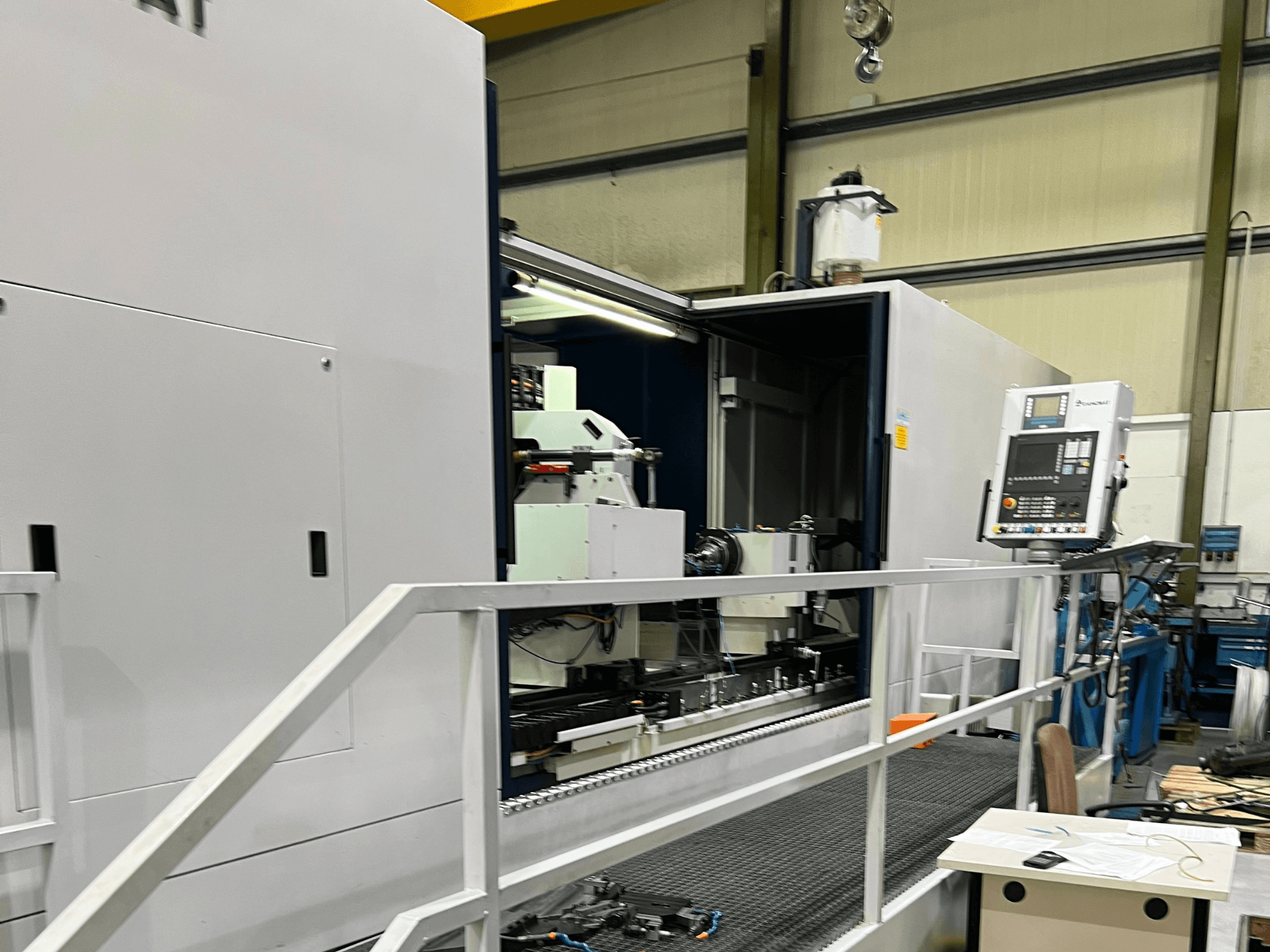 CNC obradni centar s otvorenim bočnim pogledom, na kojem su vidljive kontrole, držač alata i glavna komponenta unutra. Detalji marke nisu vidljivi.