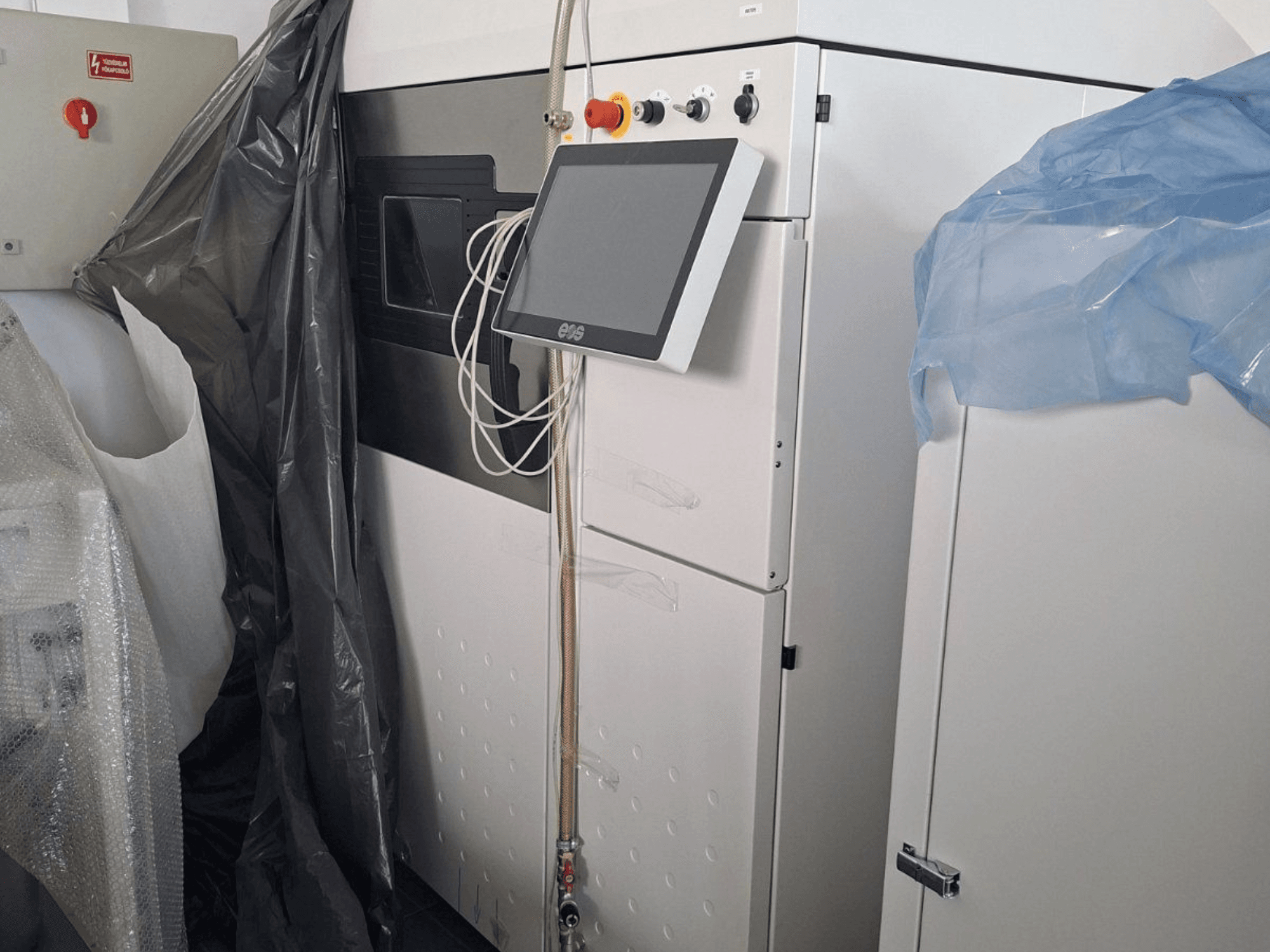 Prednji pogled na metalni 3D printer EOS M 290, sa zaslonom osjetljivim na dodir, upravljačkom pločom i zaštitnim poklopcima.