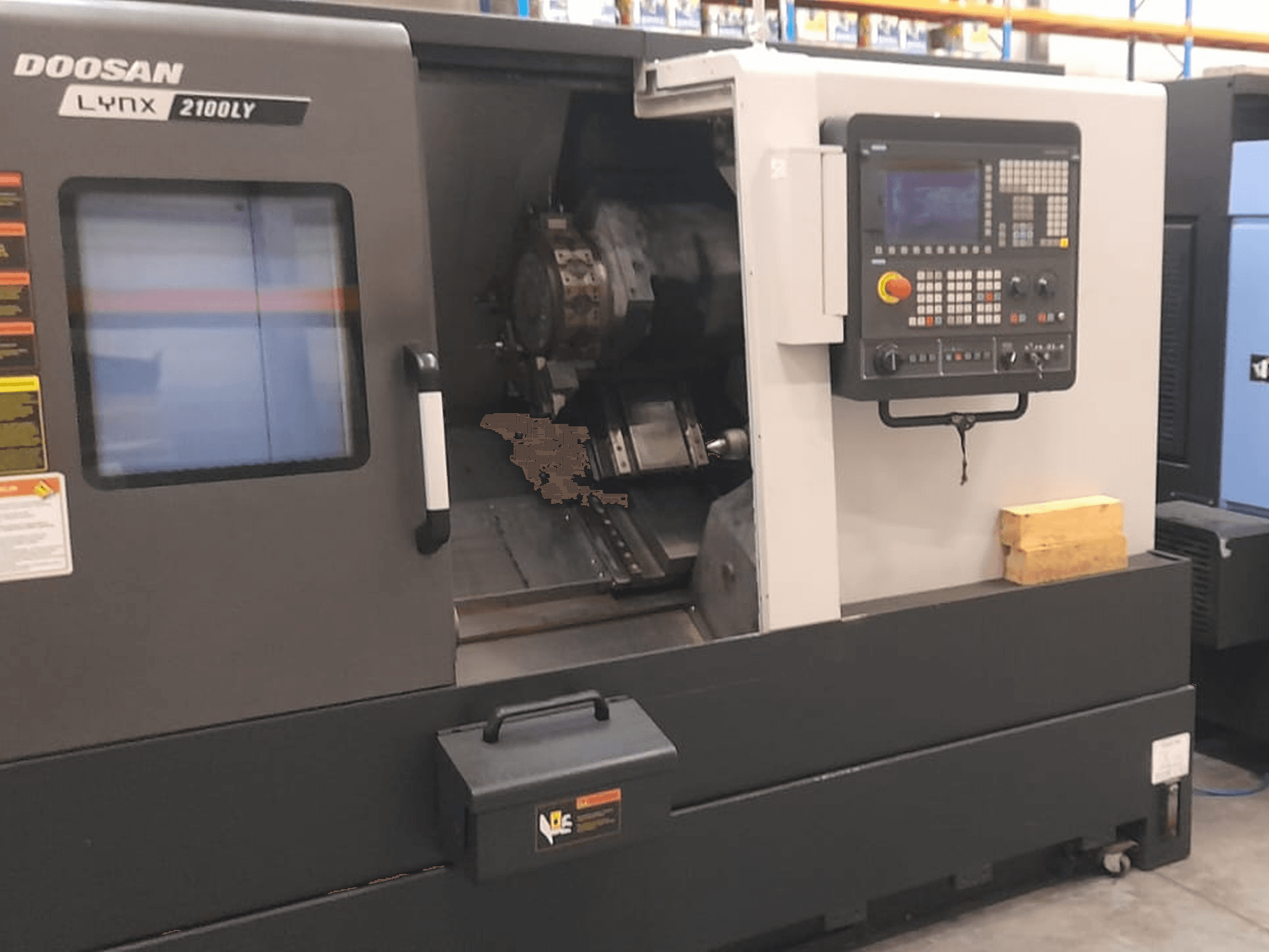 Doosan Lynx 2100LY CNC tokarski stroj, prednji pogled s upravljačkom pločom, držačem alata i unutarnjim radnim prostorom; vidljive tehničke naljepnice.