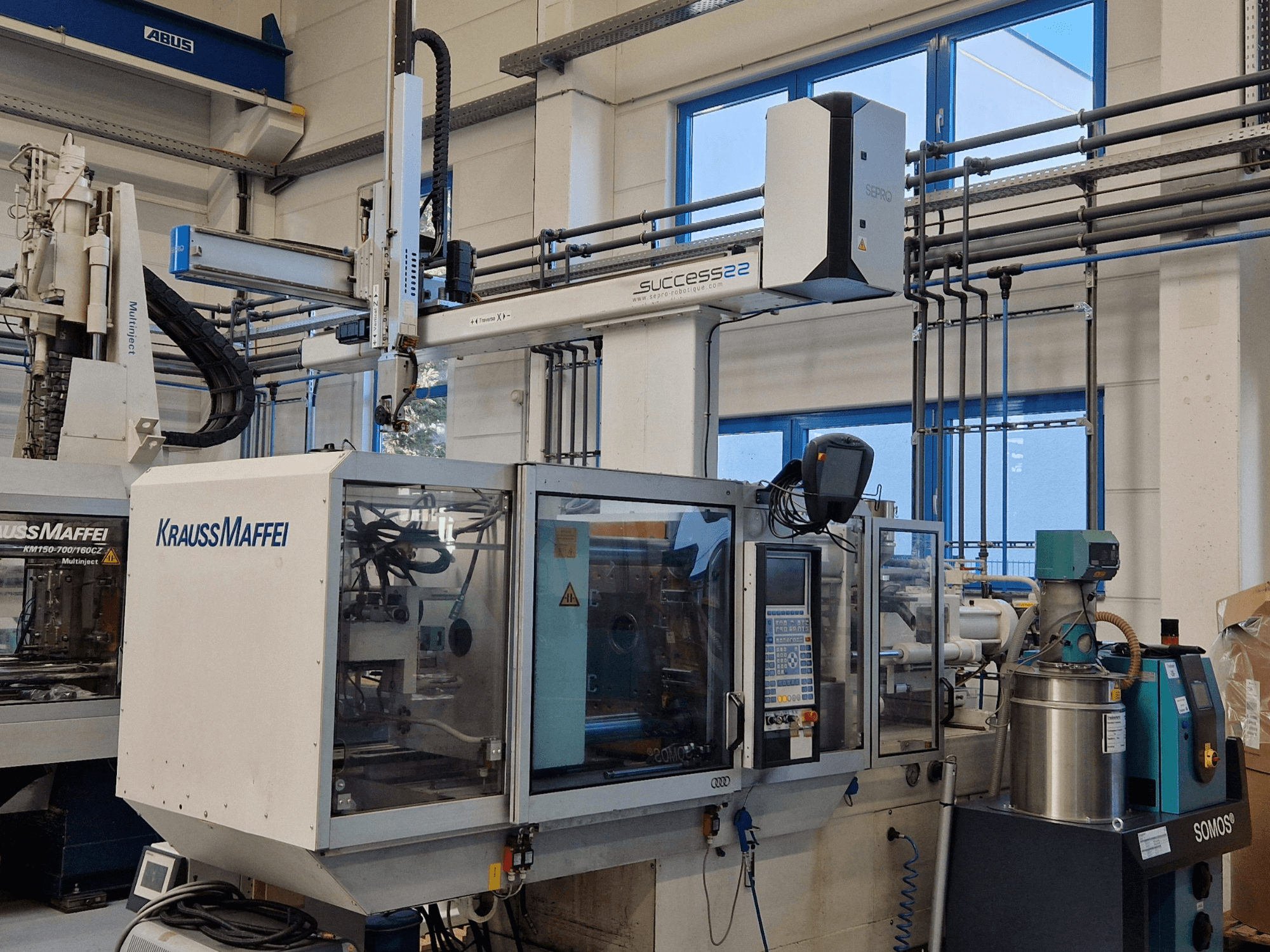 Stroj za brizganje plastike KraussMaffei Success 22 s upravljačkom pločom, pogled sprijeda u tvorničkom okruženju.