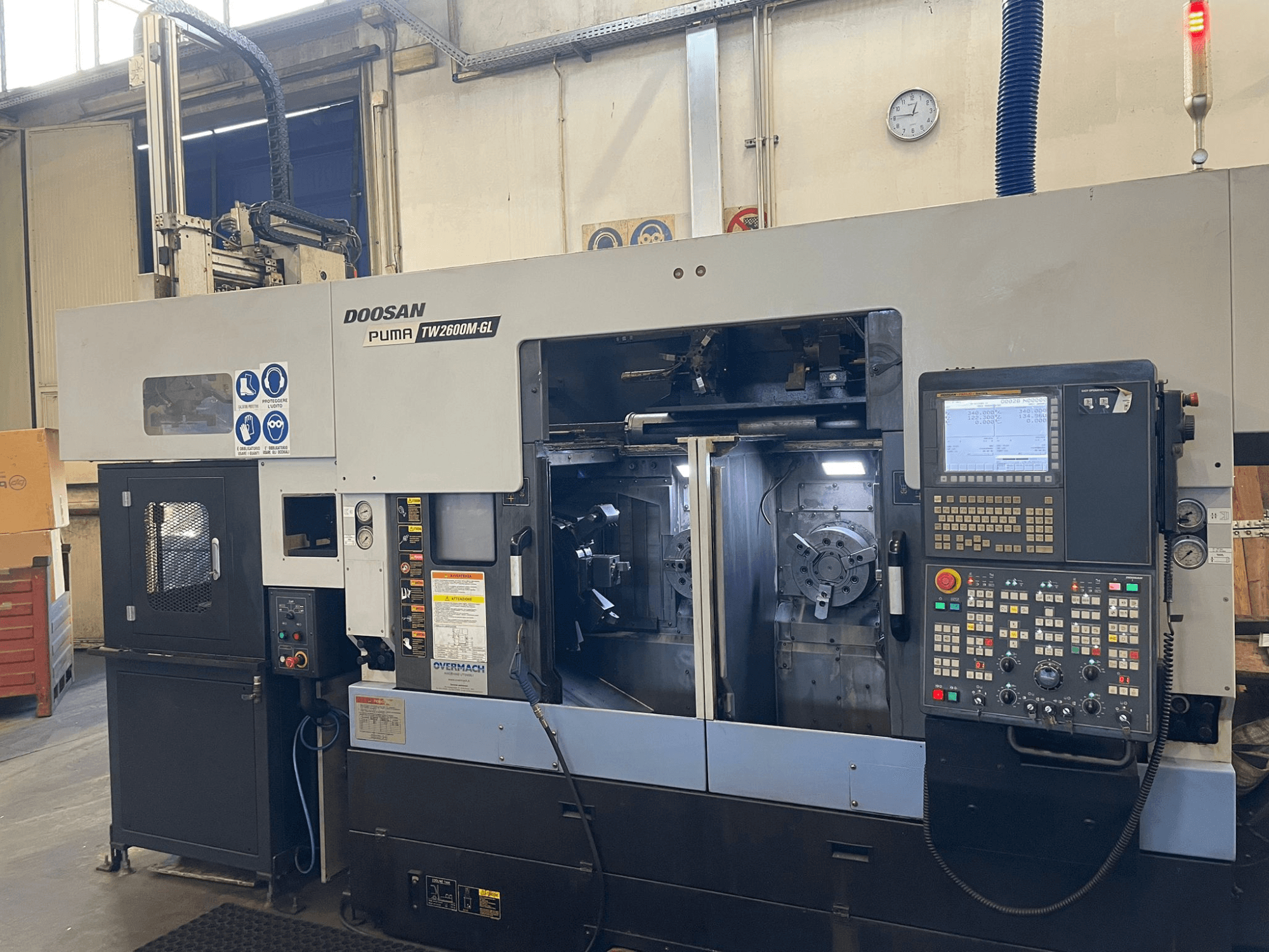 Doosan Puma TW2600M GL CNC tokarski stroj, prednji pogled, prikaz digitalne upravljačke ploče i unutrašnjosti stroja s držačima alata.