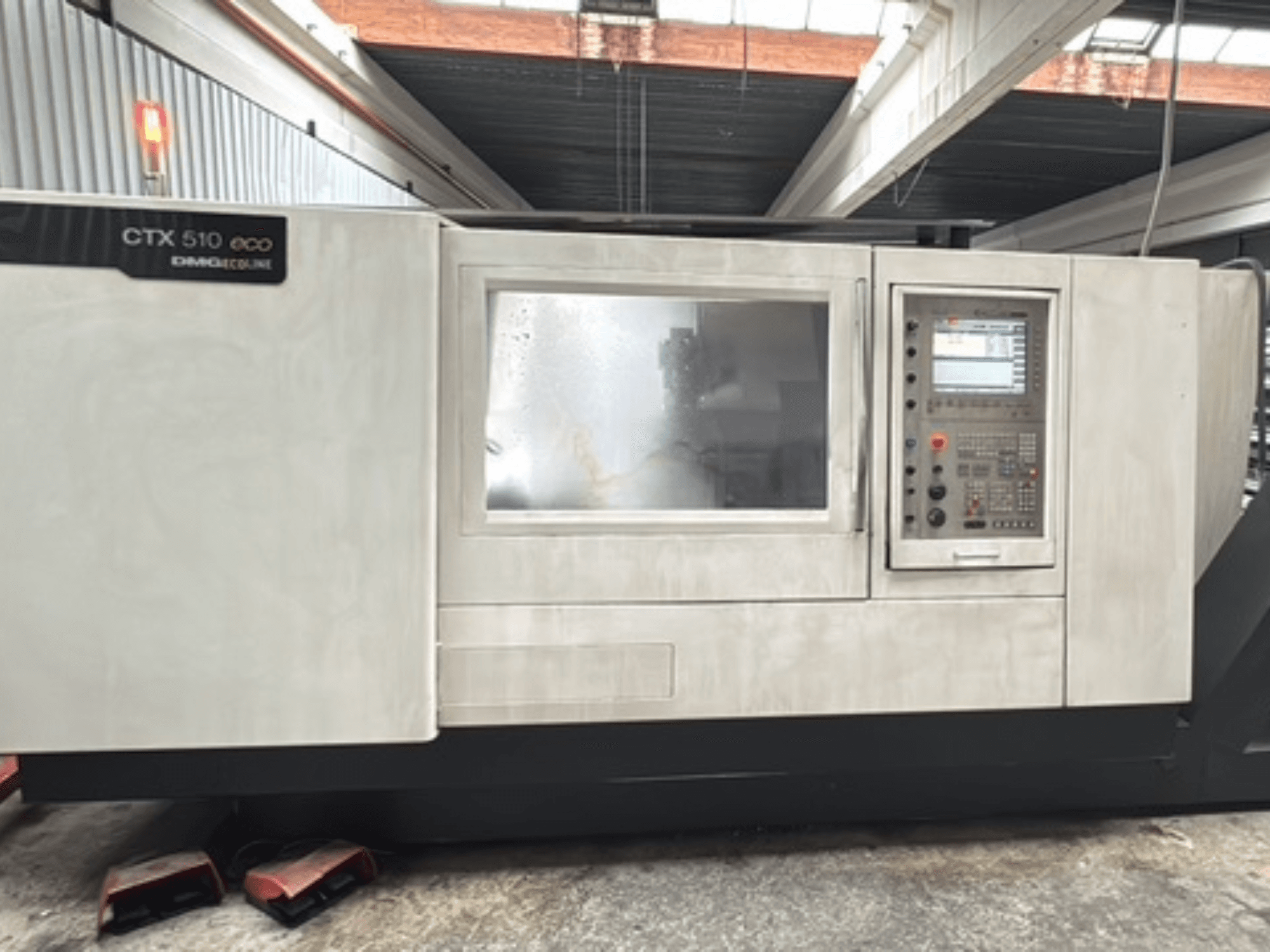 Horizontalni tokarski stroj DMG CTX 510 ecoline, prednji pogled, prikaz upravljačke ploče i prozora na kućištu stroja.