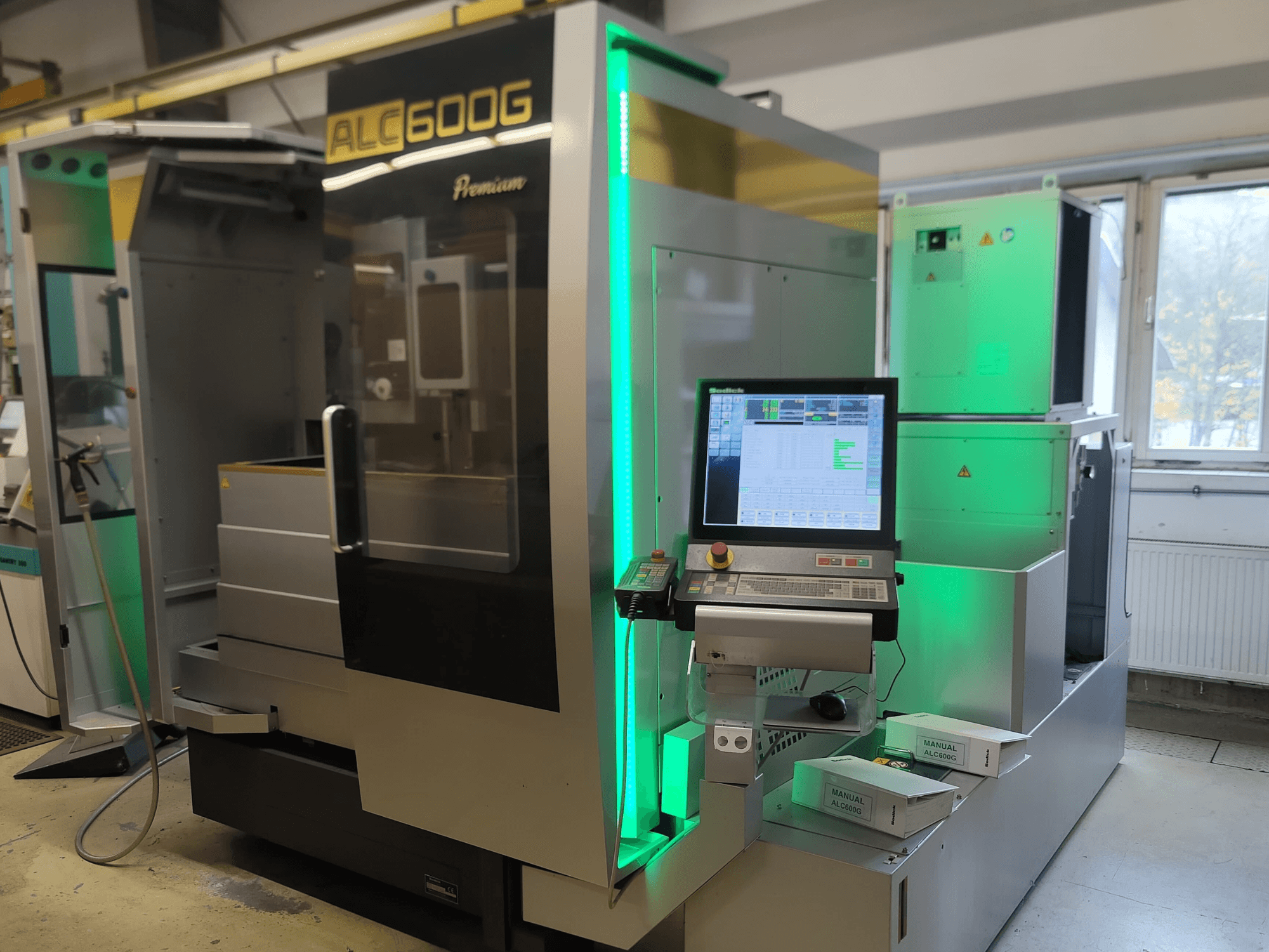 Sodick ALC600G Premium žičani EDM stroj, prednji pogled, prikaz upravljačke ploče i osvijetljenih vanjskih detalja.