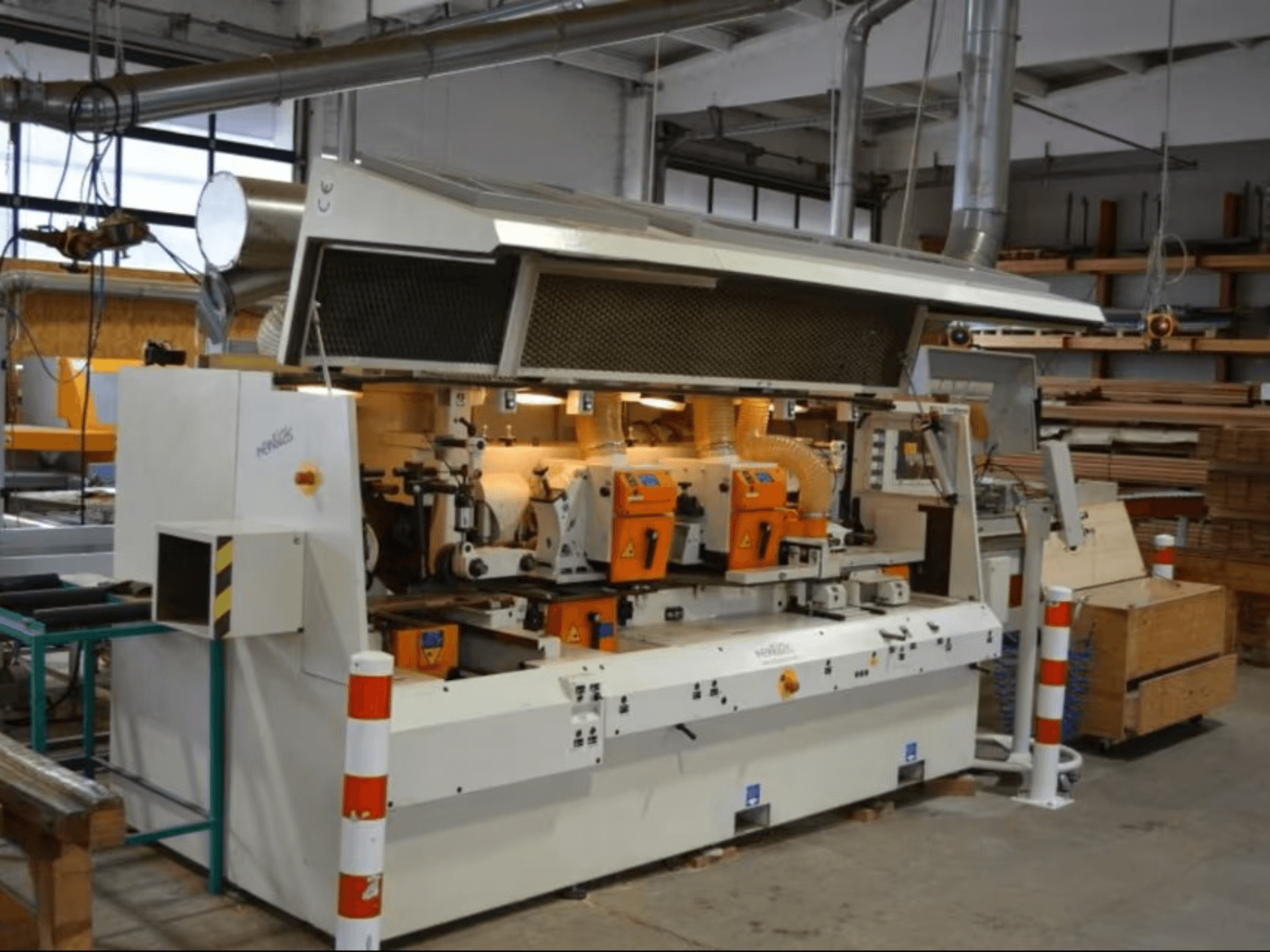 Stroj za obradu drva PENIGAS, pogled sprijeda, s dvostrukim narančastim reznim glavama i sustavom za usisavanje prašine u radioničkom okruženju.