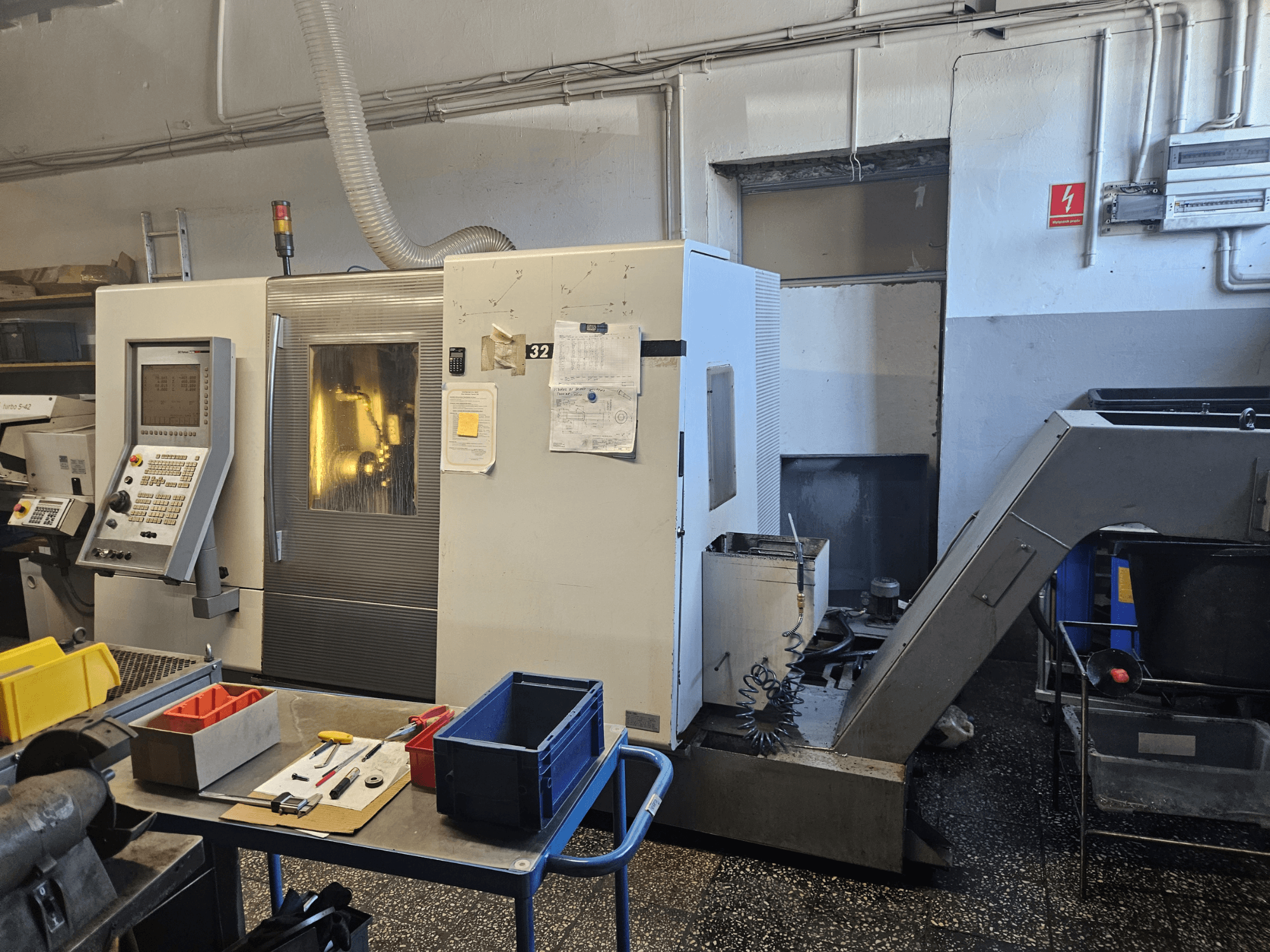 Viševretenasta tokarska mašina DMG GILDEMEISTER Sprint 32 linear, prednji pogled u radionici, s vidljivom upravljačkom pločom i alatima.