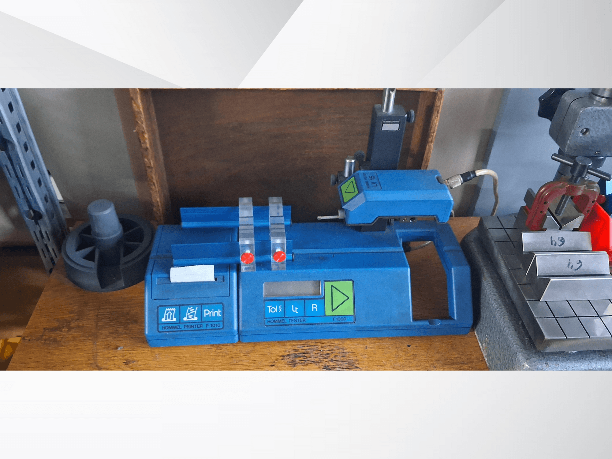 Hommel pisač P 1010 i tester T1000 u bočnom pogledu, s plavim kućištem, gumbima i crvenim indikatorima, na radnom stolu.