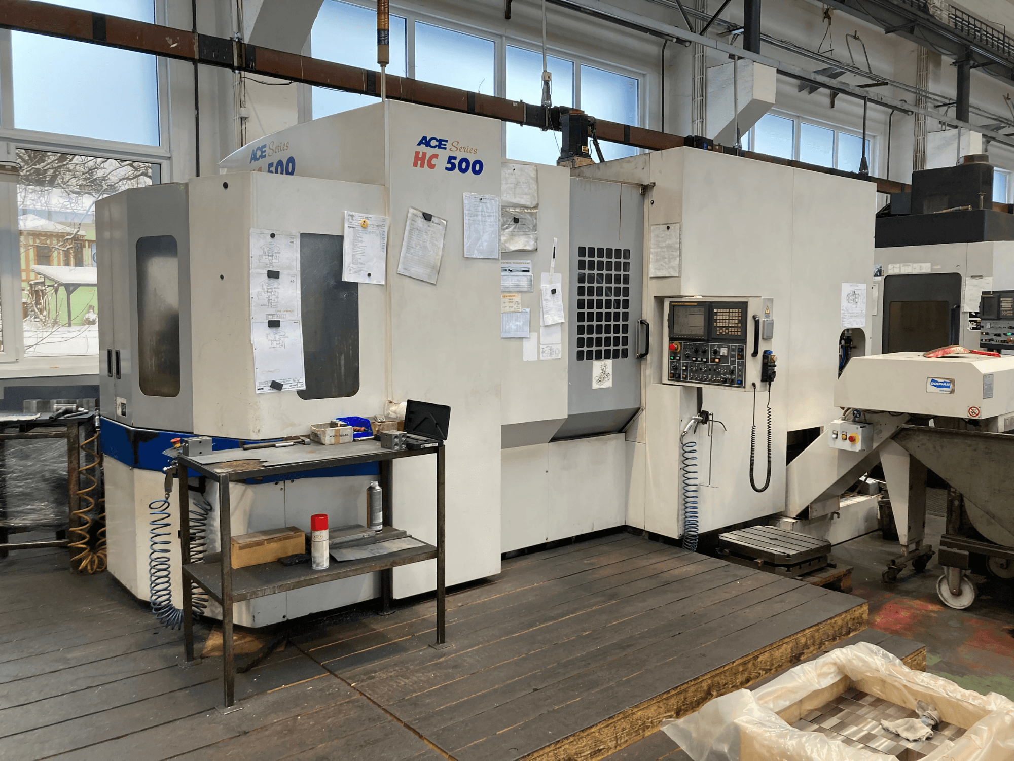 Horizontalni obradni centar DOOSAN ACE HC-500, prednji pogled; ima upravljačku ploču, višestruki spremnik alata i industrijski postav.