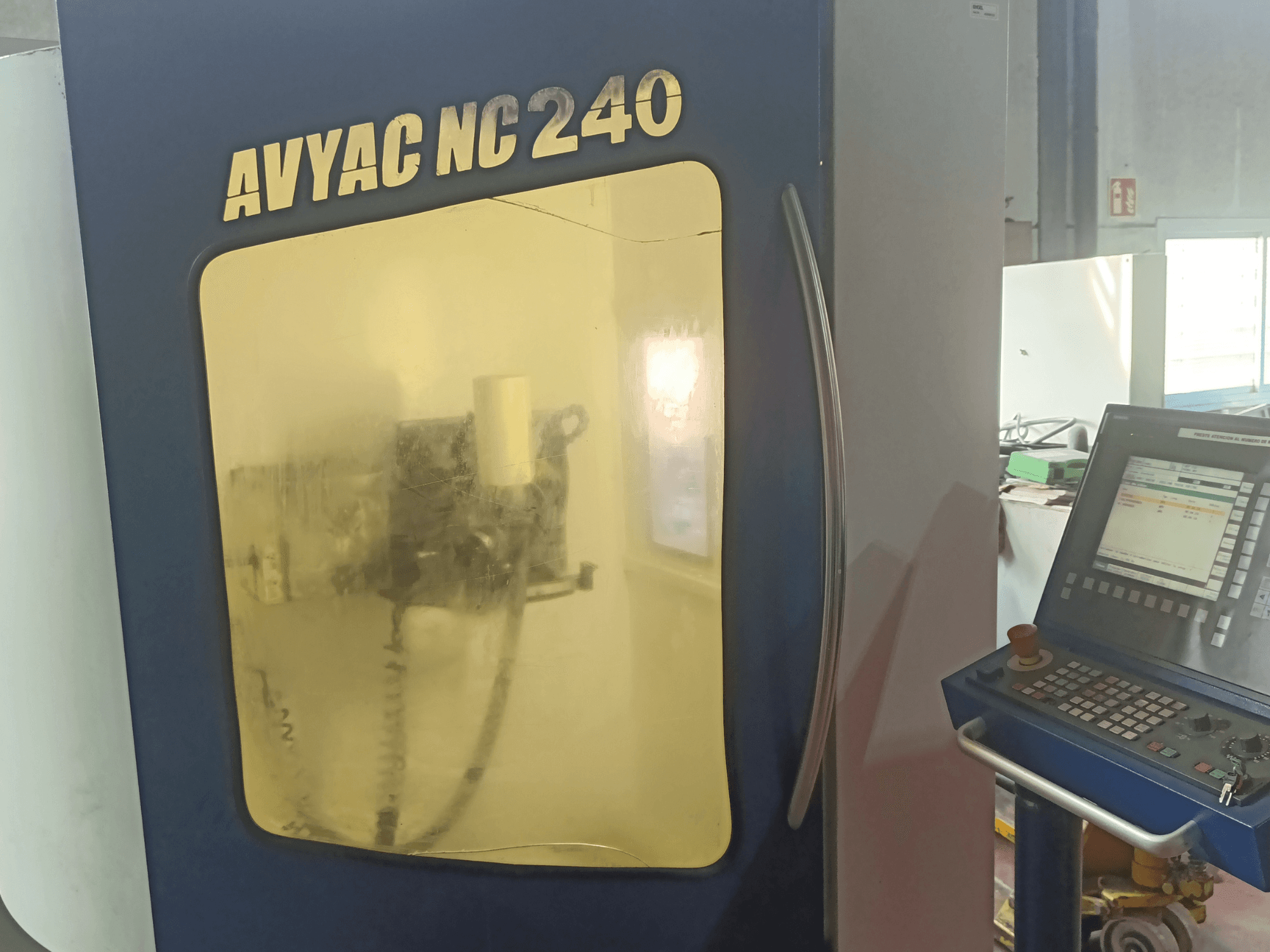 AVYAC NC240 cilindrična brusilica, bočni pogled s upravljačkom pločom i djelomično vidljivim područjem brušenja kroz prozor.