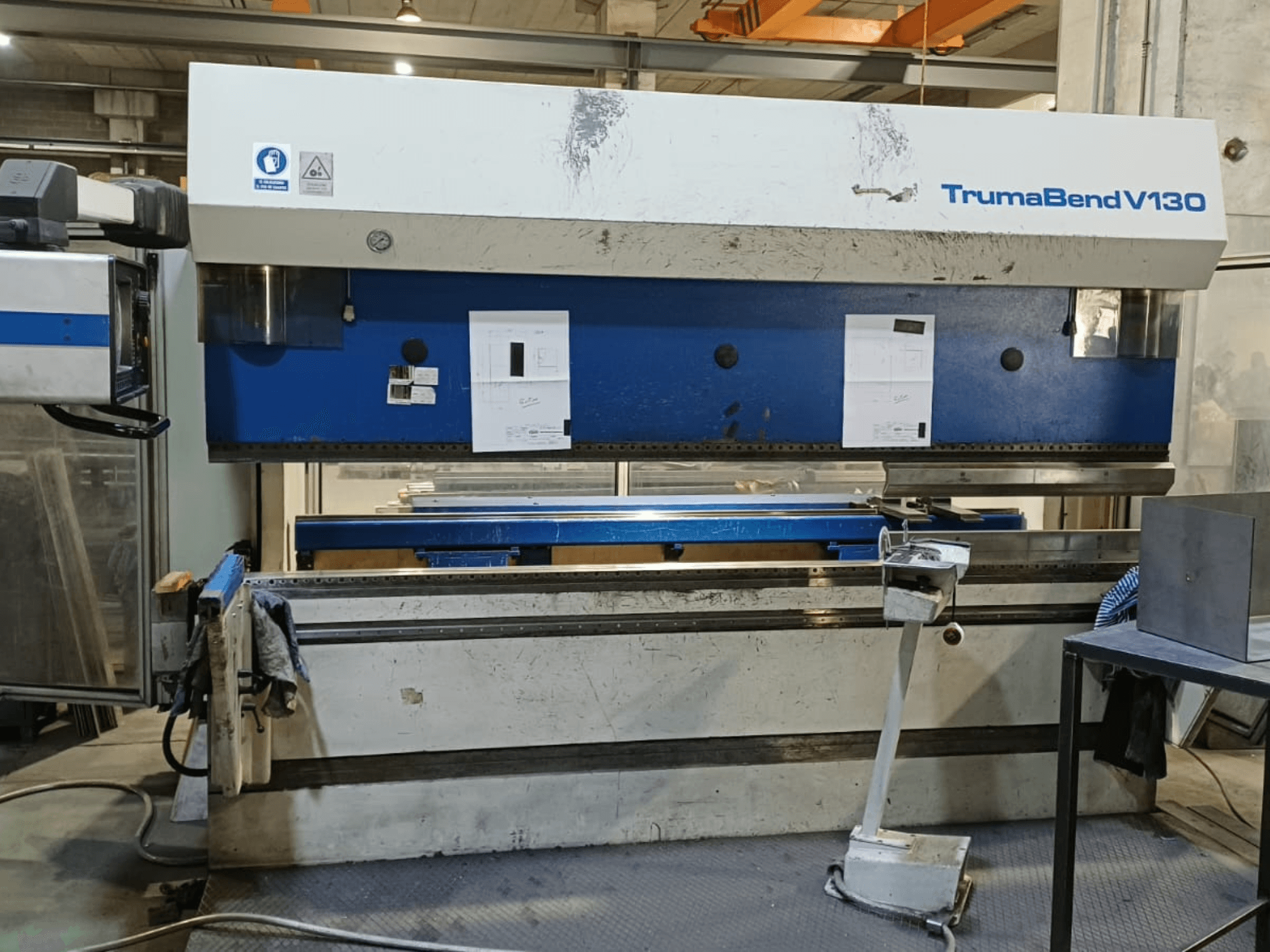 TRUMPF Trumatic Trumabend V130 preša za savijanje u prednjem pogledu, s prikazom upravljačke ploče, radne površine i podesivih alata.