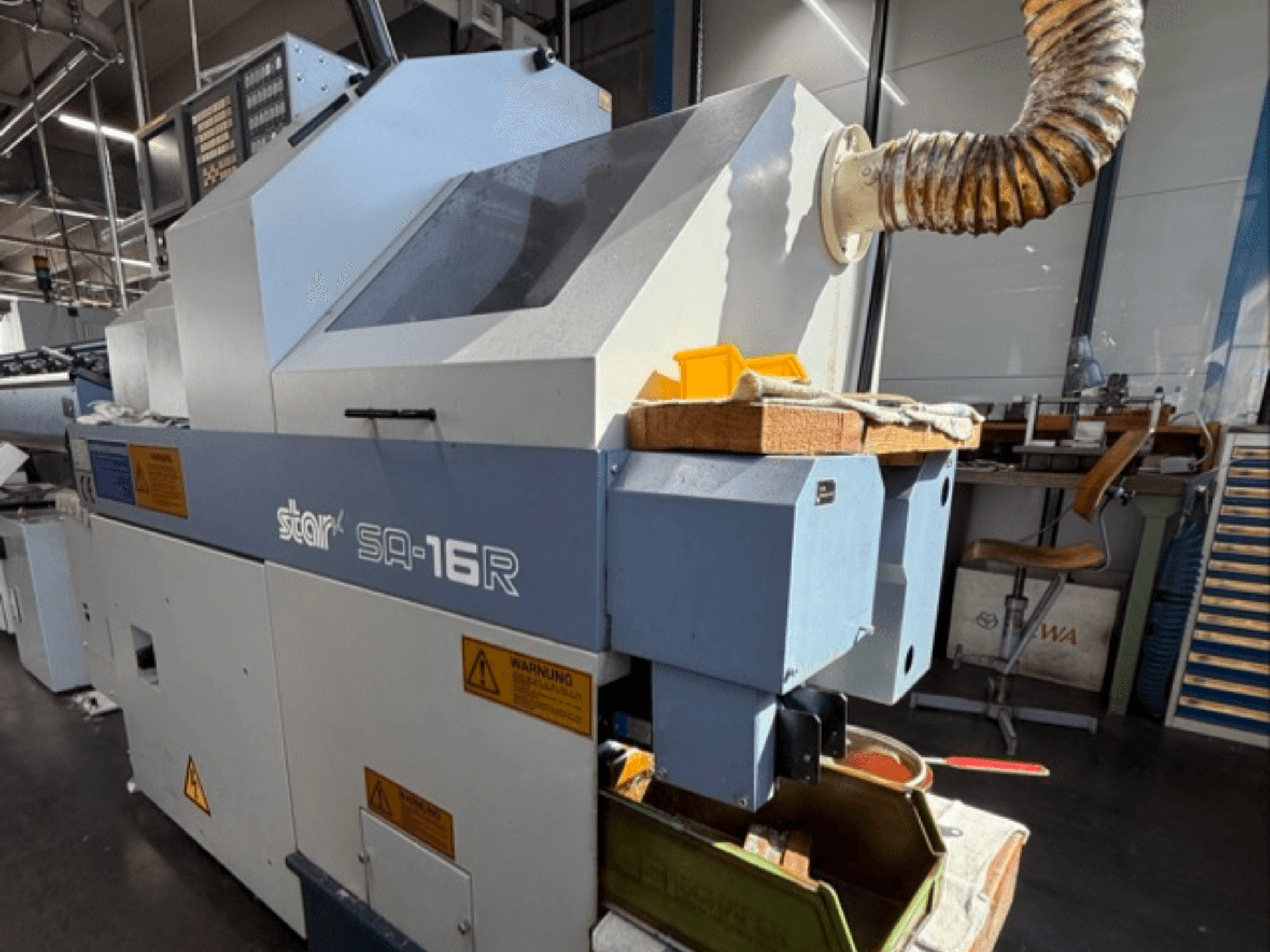 Stark SA-16R stroj gledan sprijeda, sa suženim ispuhom i radnim prostorom sa žutim alatima i naljepnicama s upozorenjima.