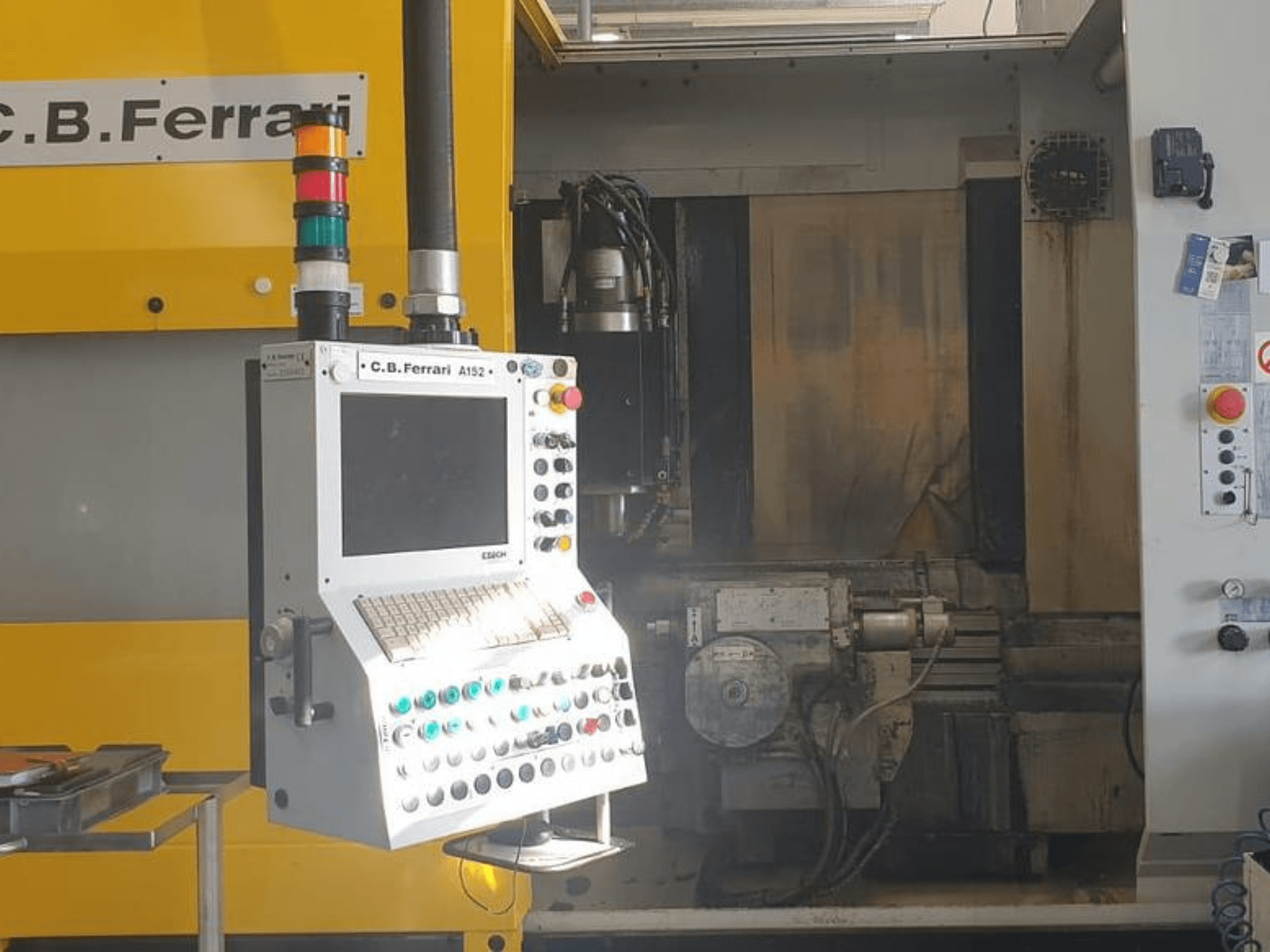 Prednji pogled na vertikalni obradni centar CB Ferrari A152, s prikazom upravljačke ploče s gumbima i komponentama motora na stroju.