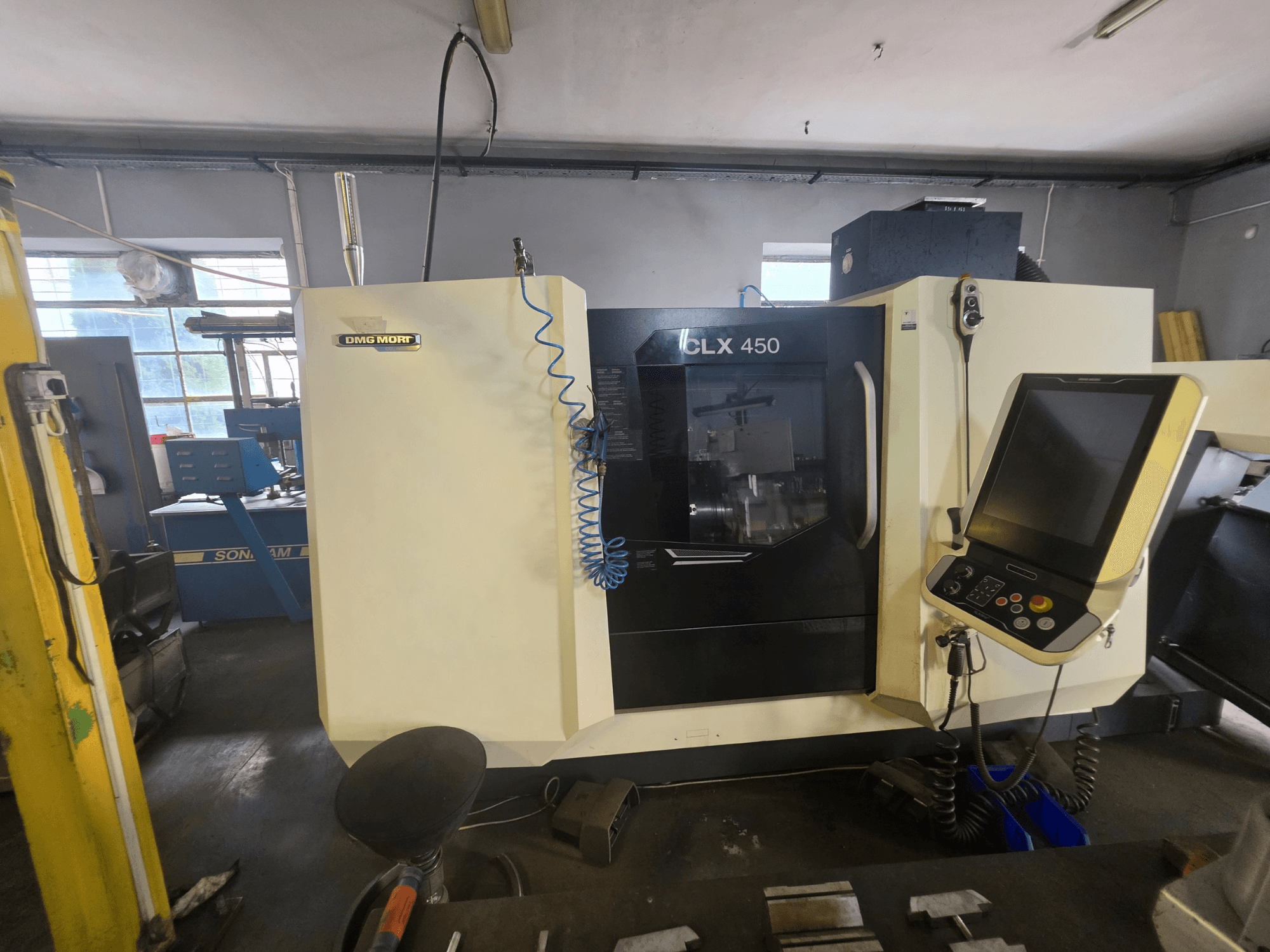 Horizontalni tokarski stroj DMG MORI CLX 450 V6 u prednjem pogledu, s upravljačkom pločom i vidljivim brendiranjem.