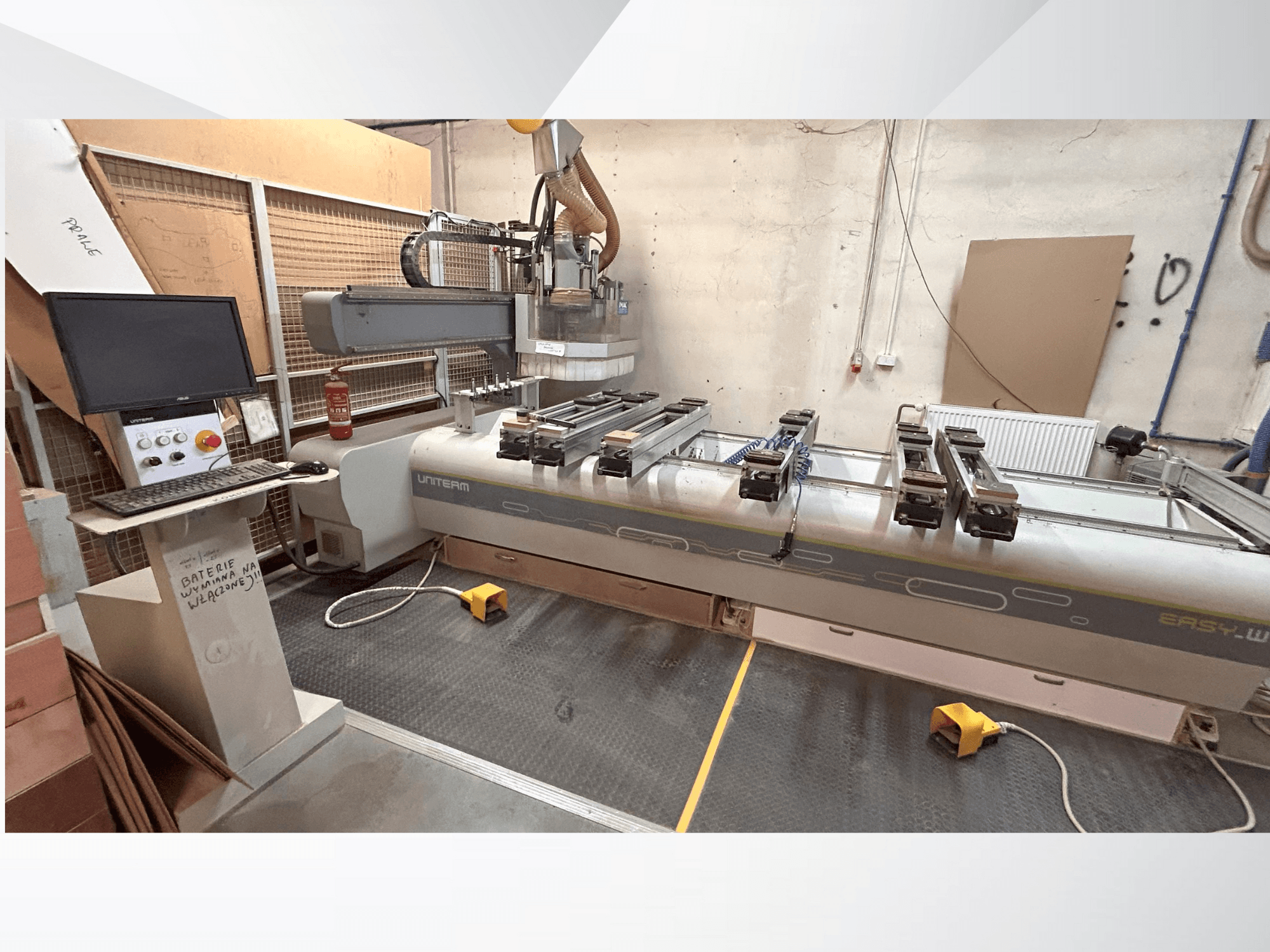 Prednji pogled na CNC stroj UNITEM EASY-W, s upravljačkom pločom, monitorom i stegnutim obratcima na radnom stolu.