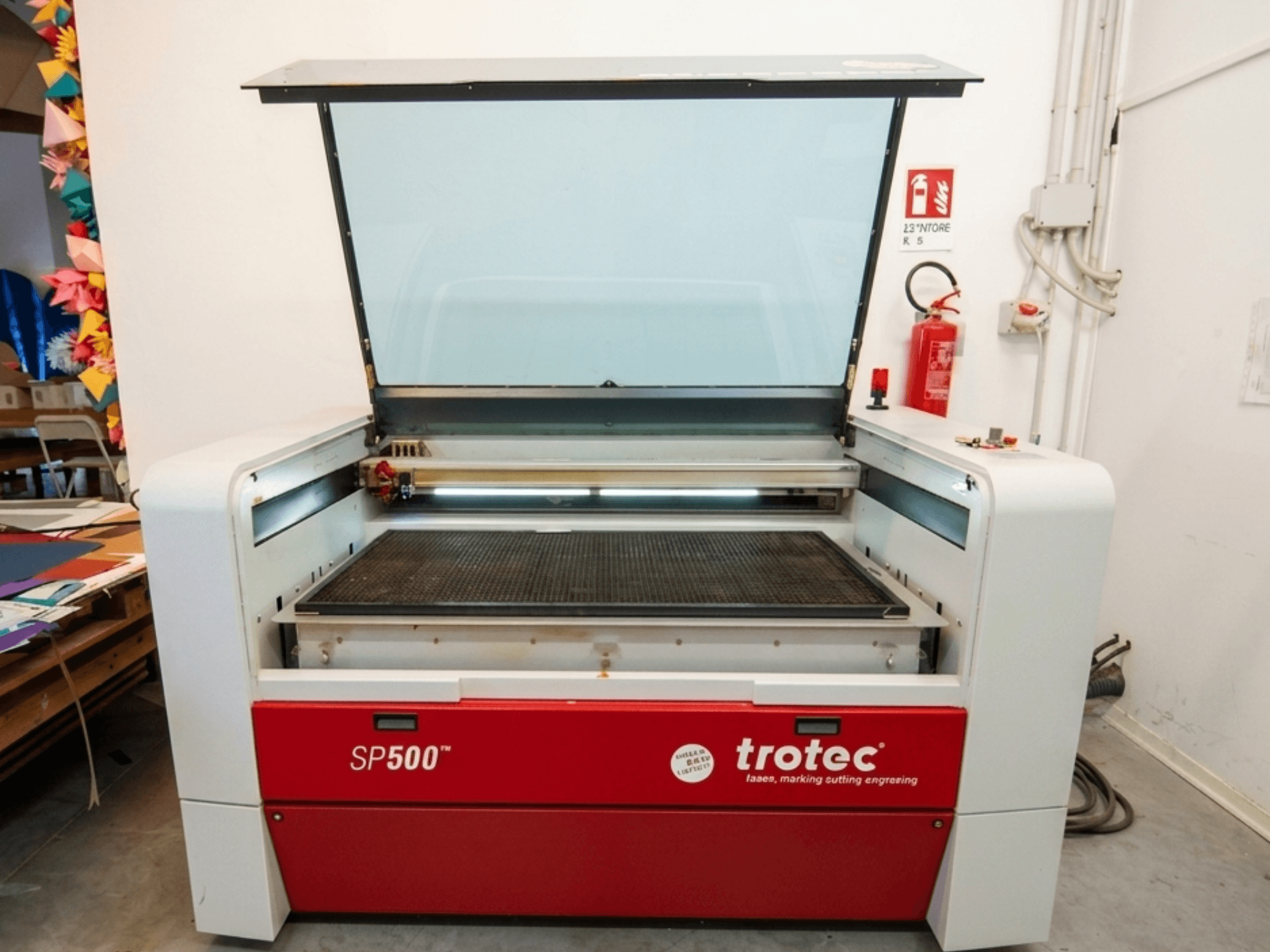Stroj za lasersko graviranje Trotec SP500 C200 u prednjem pogledu, s otvorenim poklopcem koji prikazuje radno područje i kontrole.