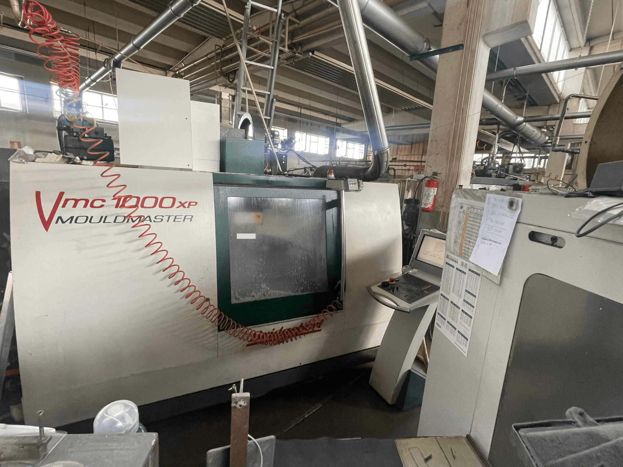 Vertikalni obradni centar Bridgeport VMC 1000, prednji pogled, prikazuje upravljačku ploču i detalje stroja u industrijskom okruženju.