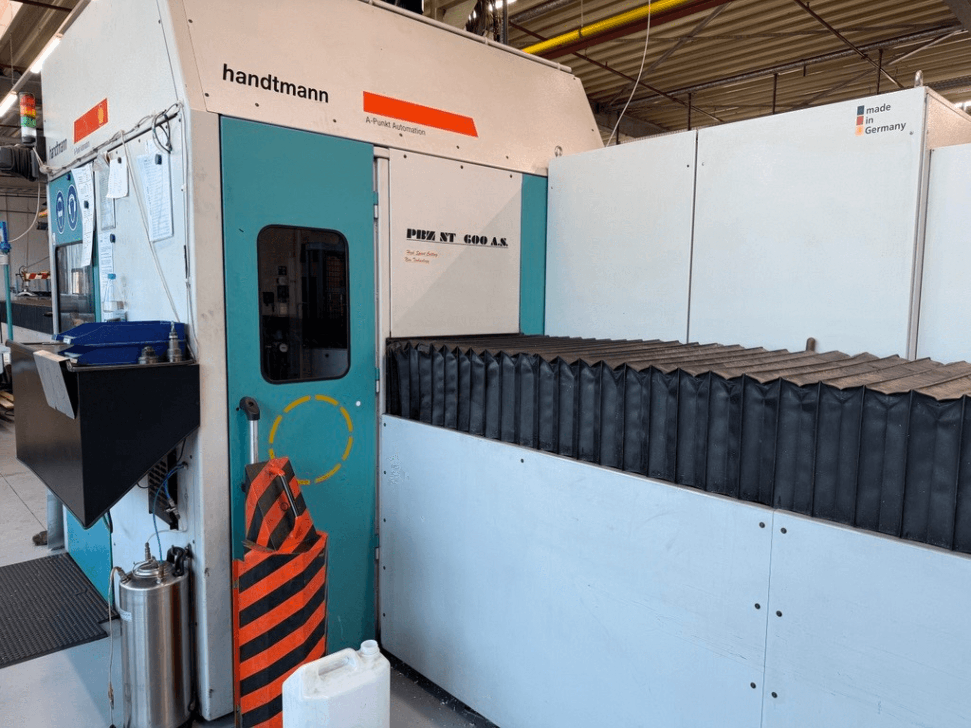 Prednji pogled na Handtmann PBZ NT 600 AS portalnu glodalicu s tamnom radnom površinom i sigurnosnim ogradama.