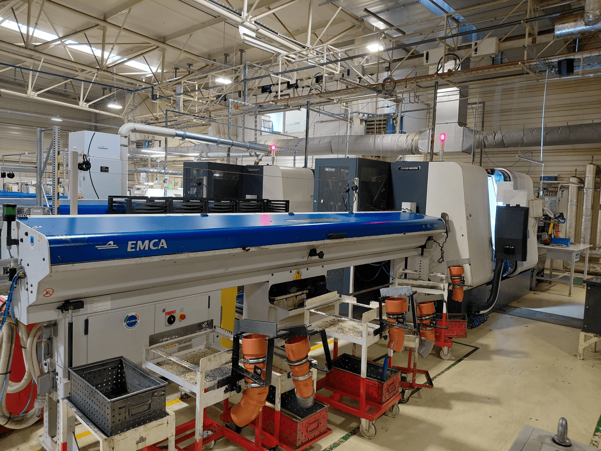DMG MORI Sprint 65 linearni viševretenski tokarski stroj u radionici, bočni pogled koji prikazuje EMCA automatizaciju i postavljanje alata.