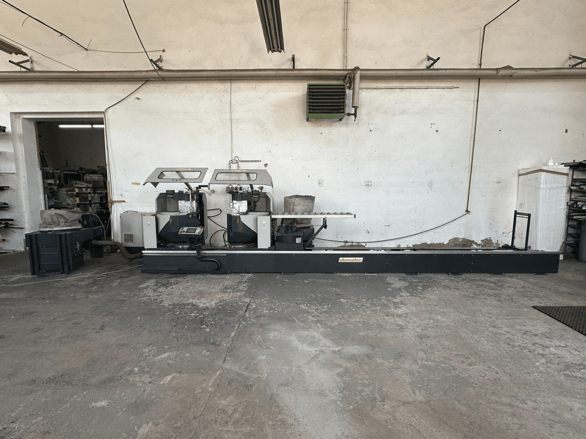 Kružna pila za metal Elumatec DG 244 u radionici, bočni pogled koji prikazuje dvostruke pile i upravljačke elemente na čvrstom postolju.