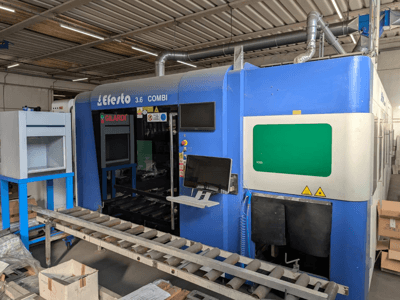 Stroj za rezanje vlaknima laserom EFESTO 3.6 COMBI, bočni pogled, s upravljačkom pločom i sigurnosnim indikatorima s plavom vanjštinom.