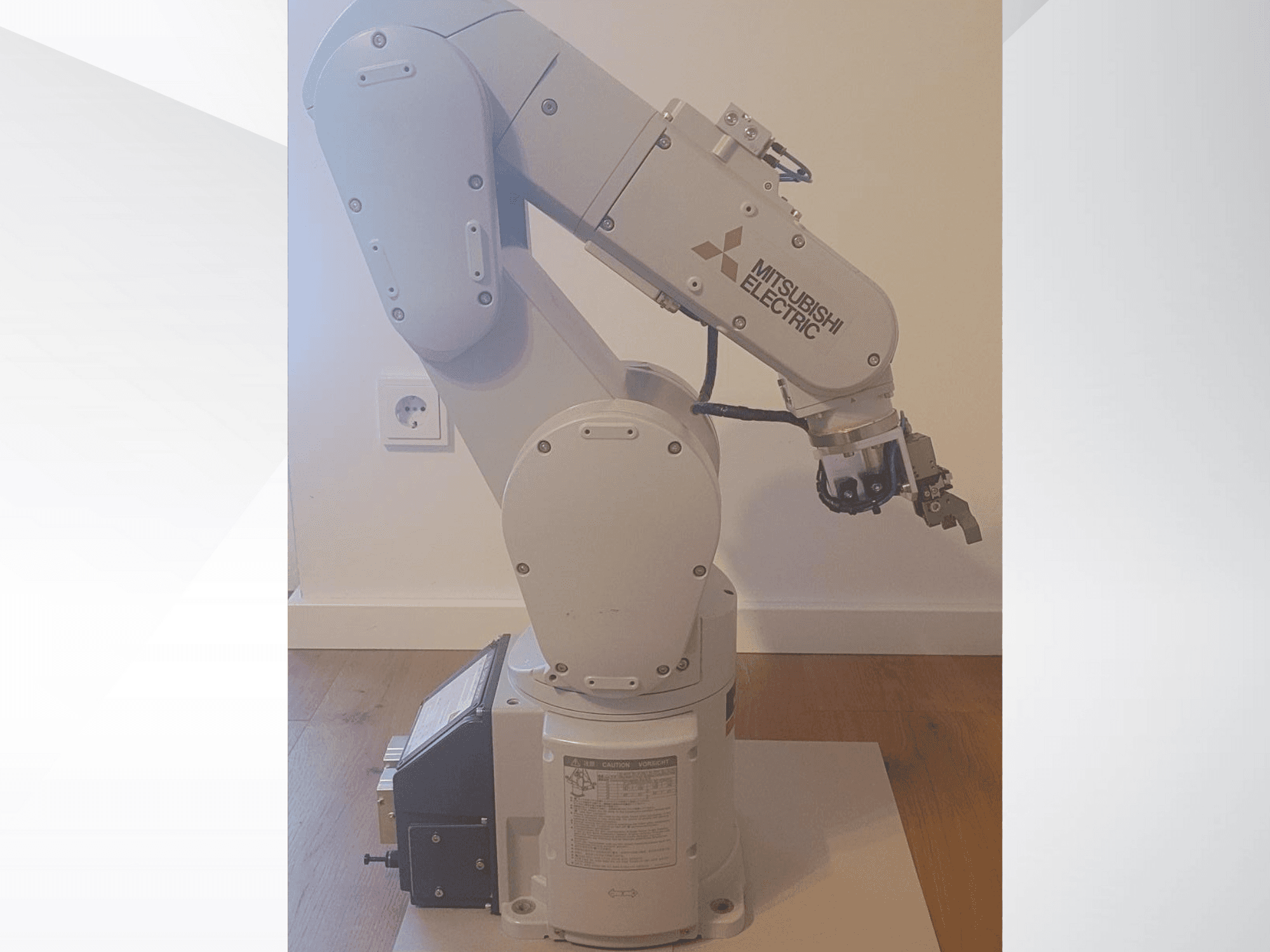 Robotska ruka Mitsubishi Electric, bočni pogled, s hvataljkom i detaljnom upravljačkom pločom na podnožju za postavke rada.