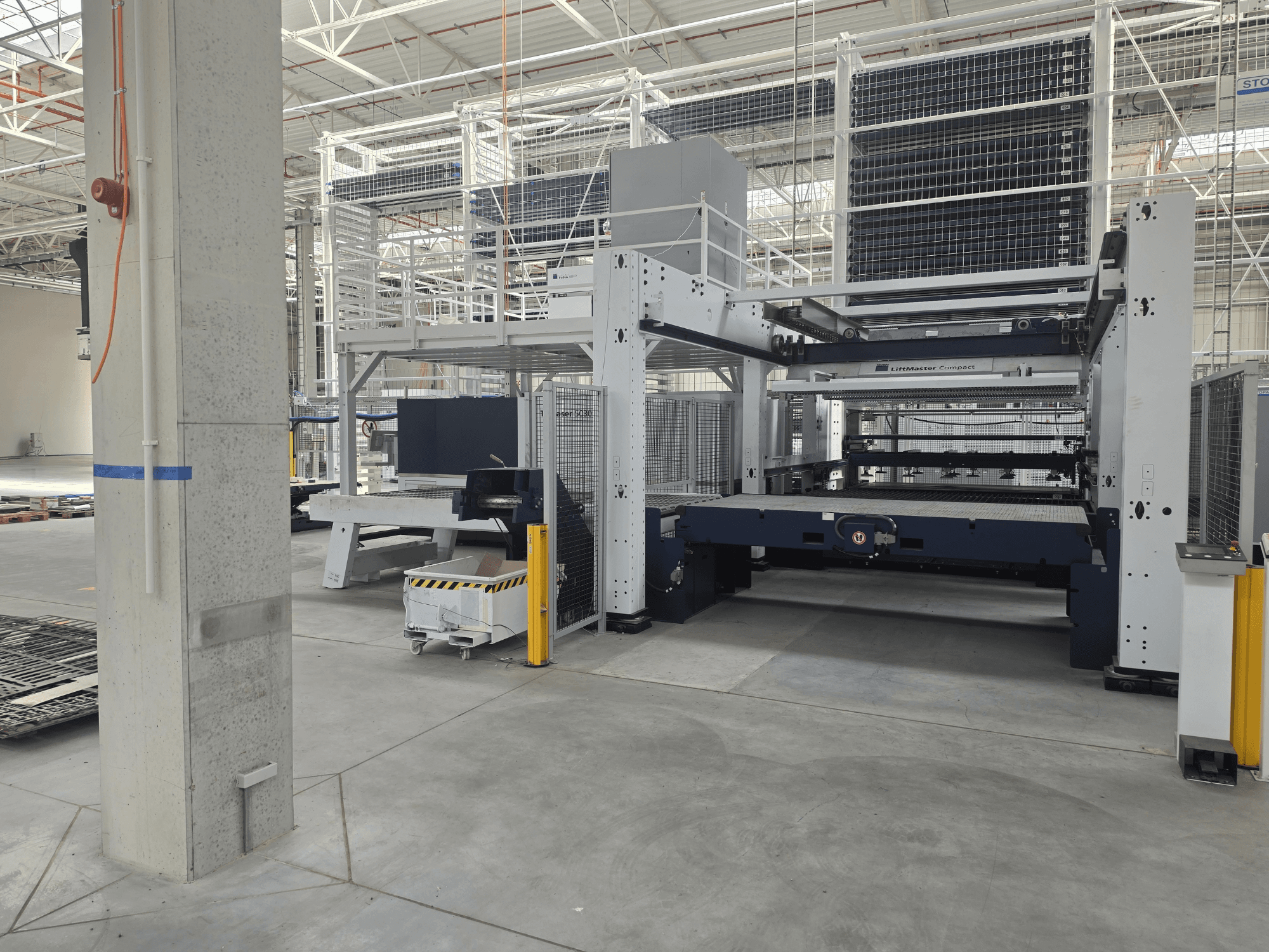 Prednji pogled na TRUMPF TruLaser 5030 fiber L76 FMC, koji prikazuje stroj za rezanje vlaknastim laserom u prostranom industrijskom okruženju.