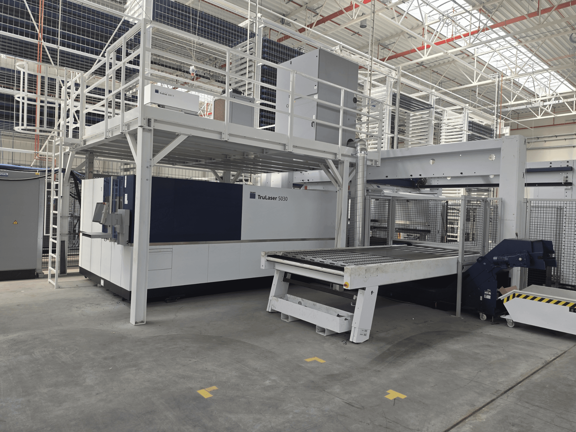 Stroj TRUMPF TruLaser 5030 fiber L76 FMC u radionici, prednji pogled koji prikazuje područje rezanja i mehanizam za utovar/istovar.