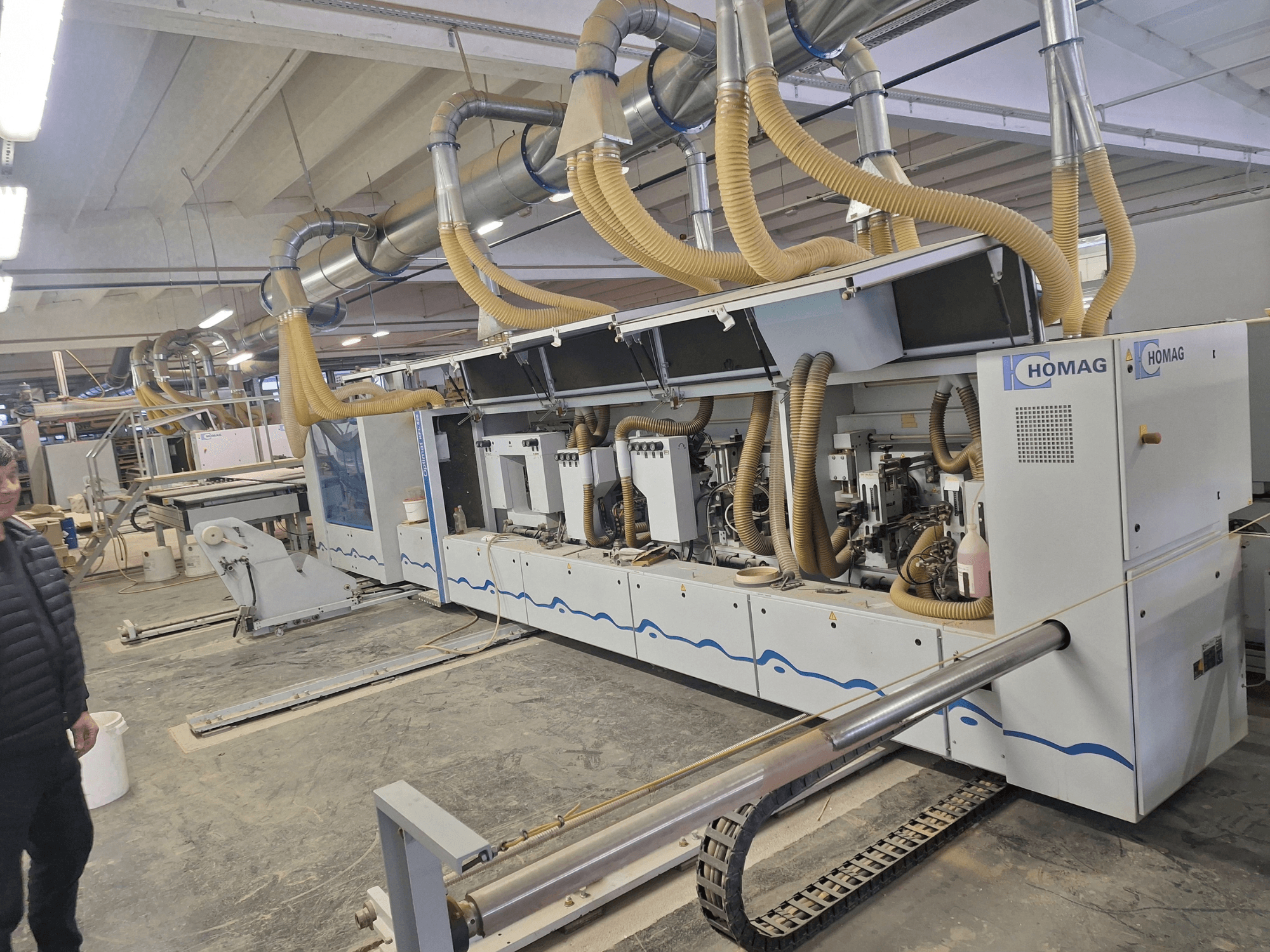 HOMAG stroj za obradu drveta u tvorničkom okruženju, prednji pogled s više vretena i sustavom za usisavanje prašine.