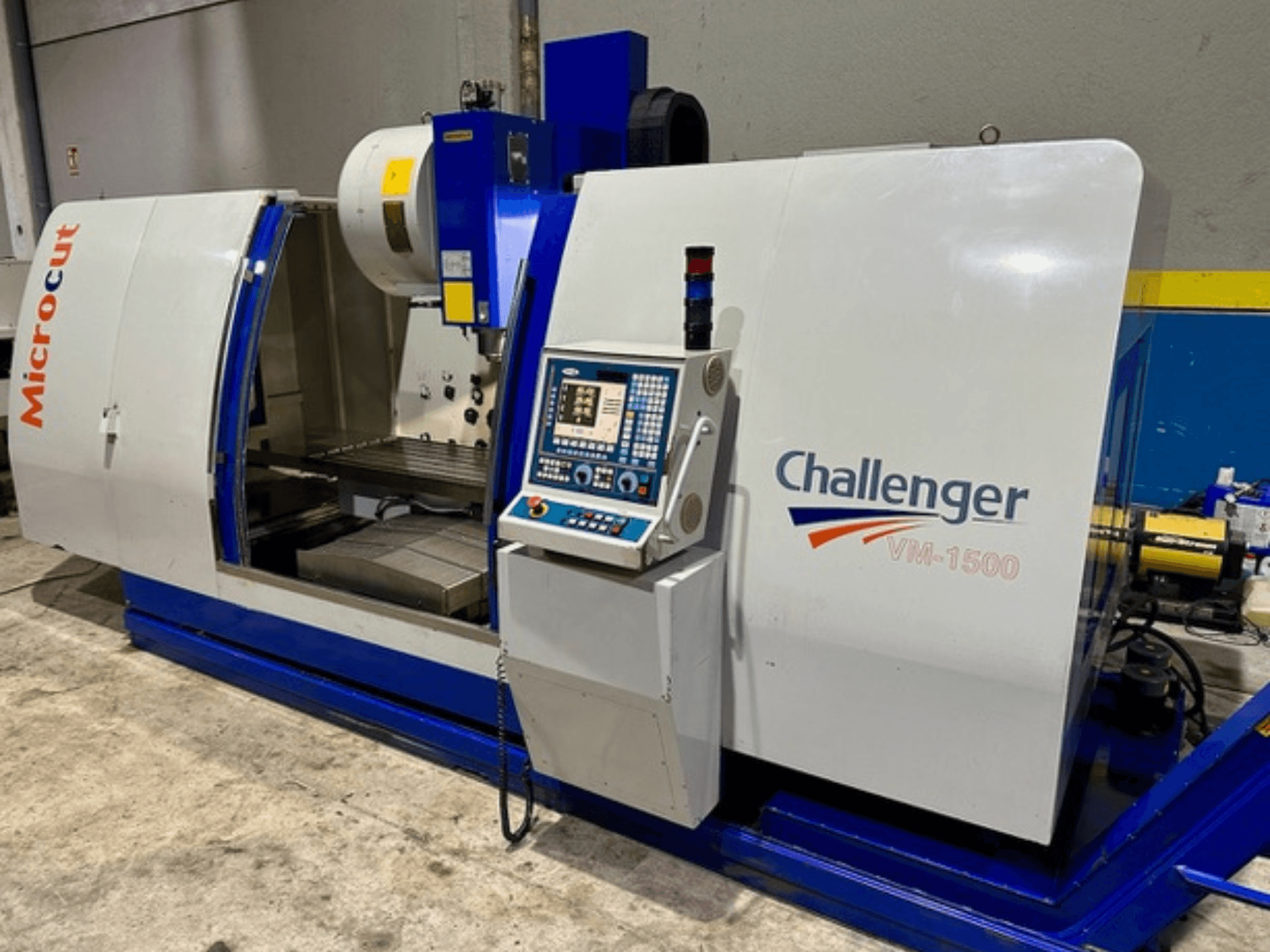 CNC stroj Microcut Challenger VM-1500, prednji pogled, sadrži upravljačku ploču, radni prostor i plavo postolje.