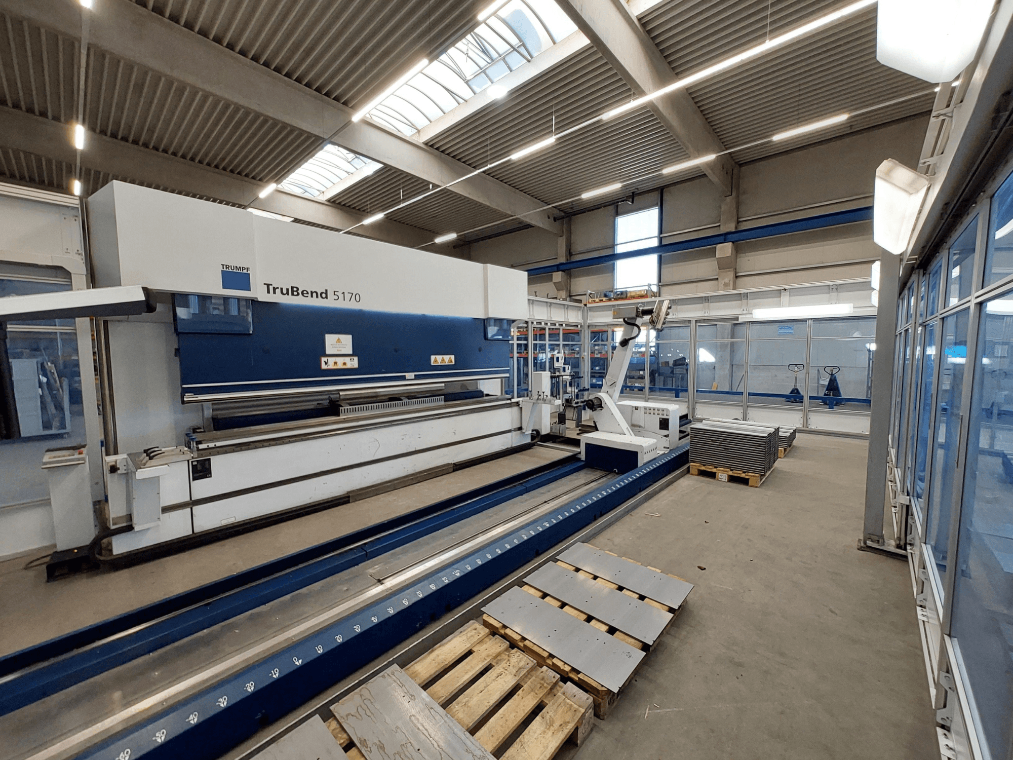 TRUMPF TruBend 5170 preša za savijanje u radionici, bočni pogled, prikazuje alat za savijanje i složene metalne limove na paletama.