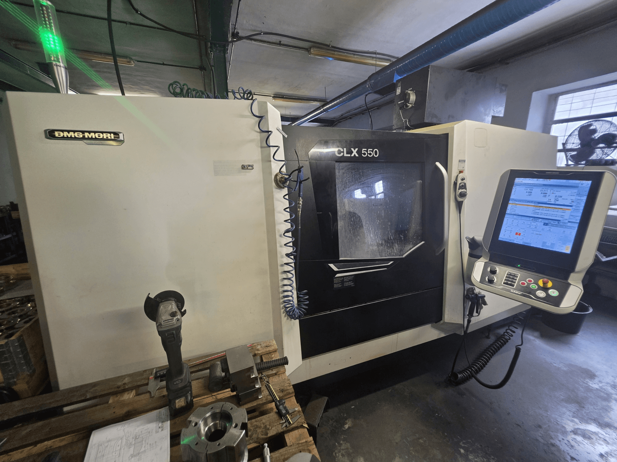 DMG MORI CLX 550 V3 horizontalni tokarski stroj, prednji pogled s upravljačkom pločom, alatima za rezanje i kućištem stroja.
