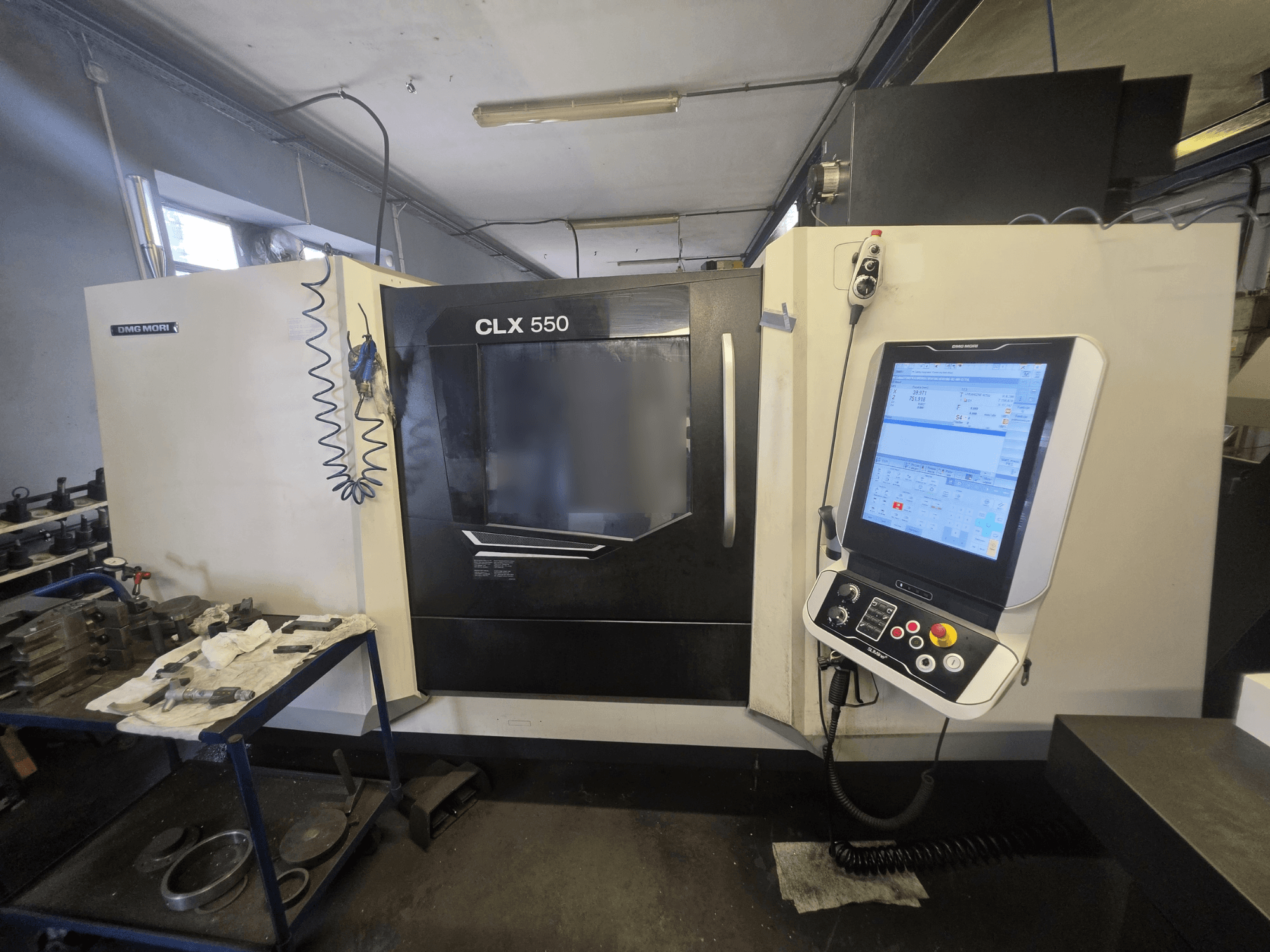 Horizontalni tokarski stroj DMG MORI CLX 550 V3, prednji pogled, prikaz upravljačke ploče i radnog prostora s alatima.