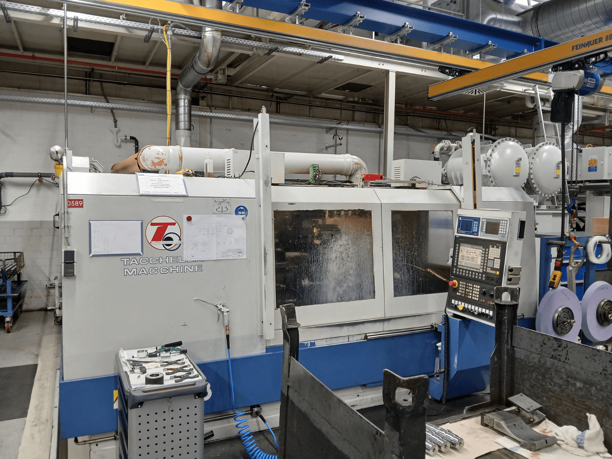 Tacchella obradni centar s prednje strane, s vidljivom upravljačkom pločom i alatima. Rashladna voda prska tijekom rada.