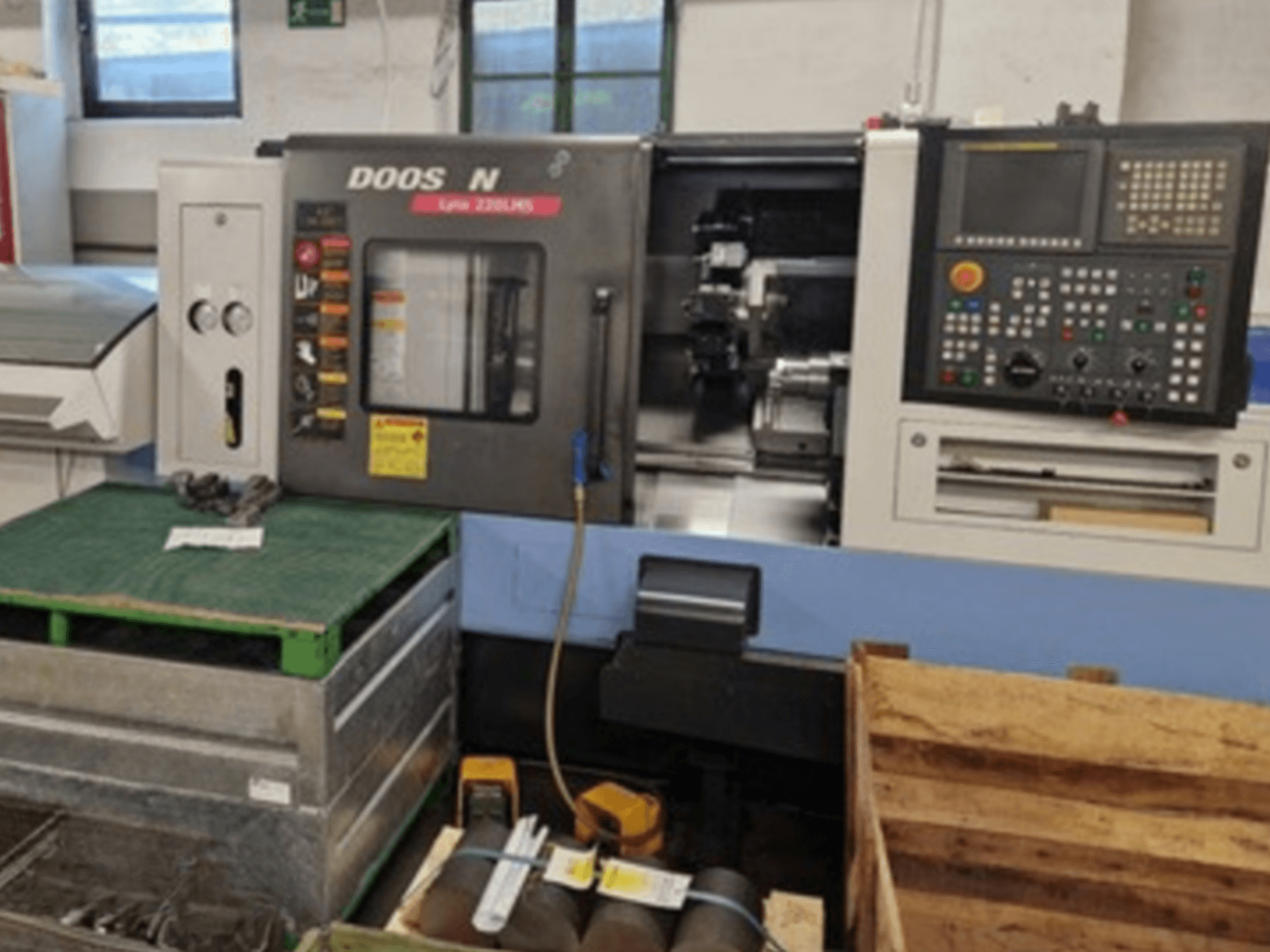 Horizontalni tokarski stroj DOOSAN Lyax 220 LMS u prednjem pogledu, s prikazom upravljačke ploče, alata i radnog prostora.