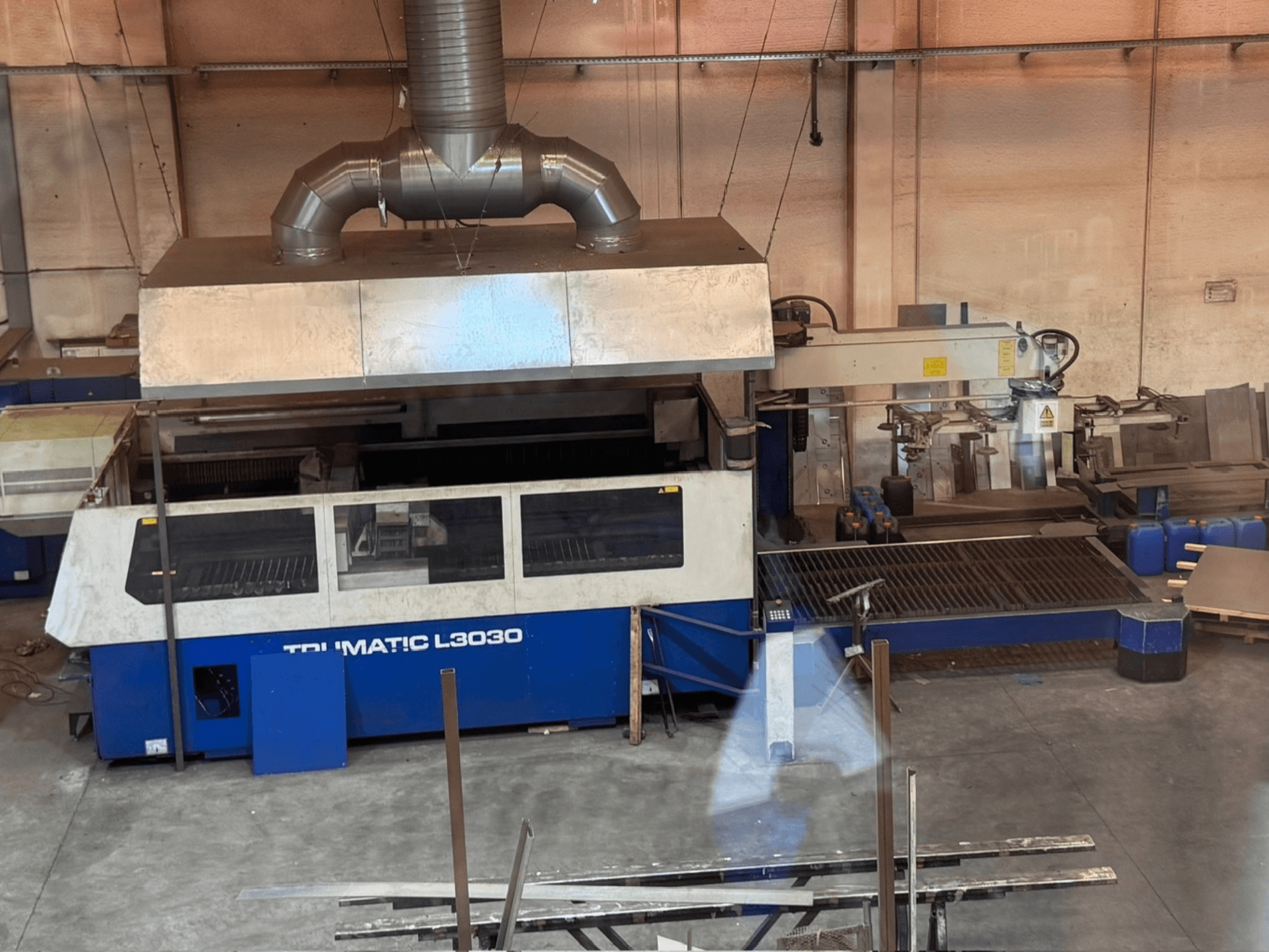 Stroj za CO2 lasersko rezanje TRUMPF TRUMATIC L3030 u radionici, prednji pogled koji prikazuje upravljačku ploču i krevet za rezanje.