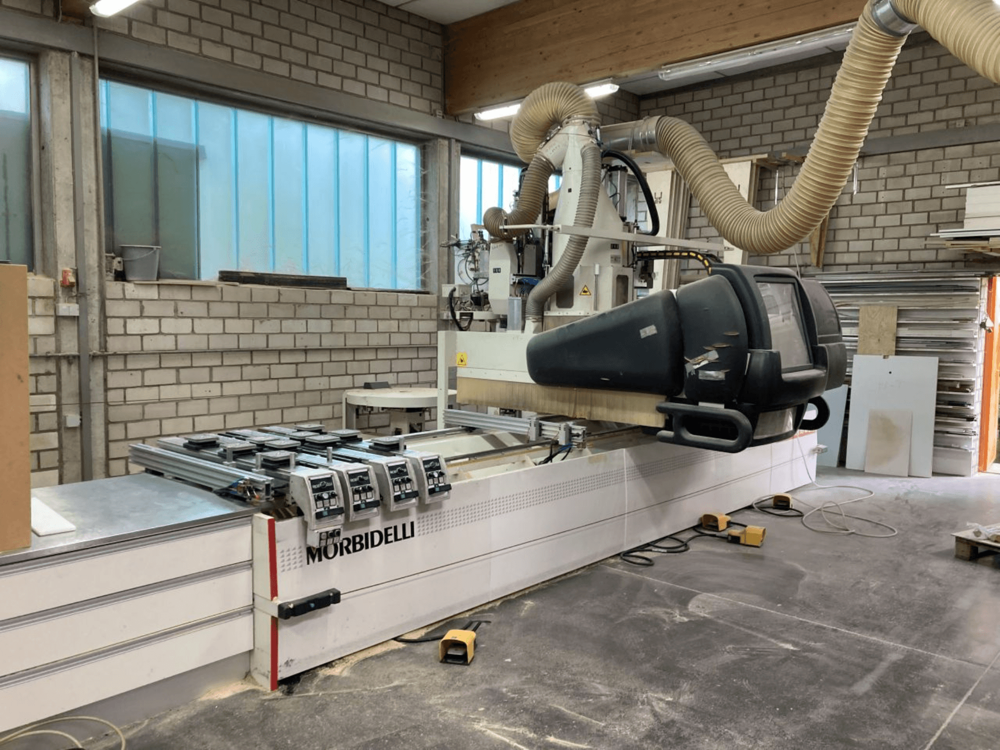 MORBIDELLI CNC stroj u radionici, prednji pogled s upravljačkom pločom, sustavom za usisavanje prašine i postavljenim komadom drva.