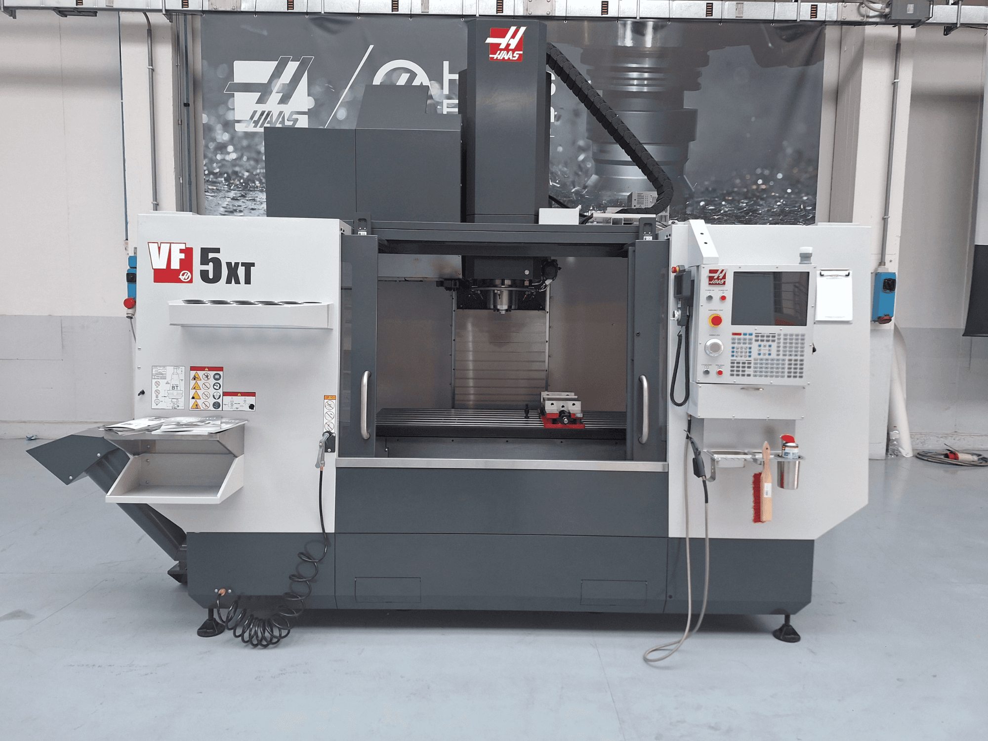 Vertikalni obradni centar HAAS VF-5/50XT, prednji pogled, prikaz upravljačke ploče, prostora za vreteno i spremišta alata.