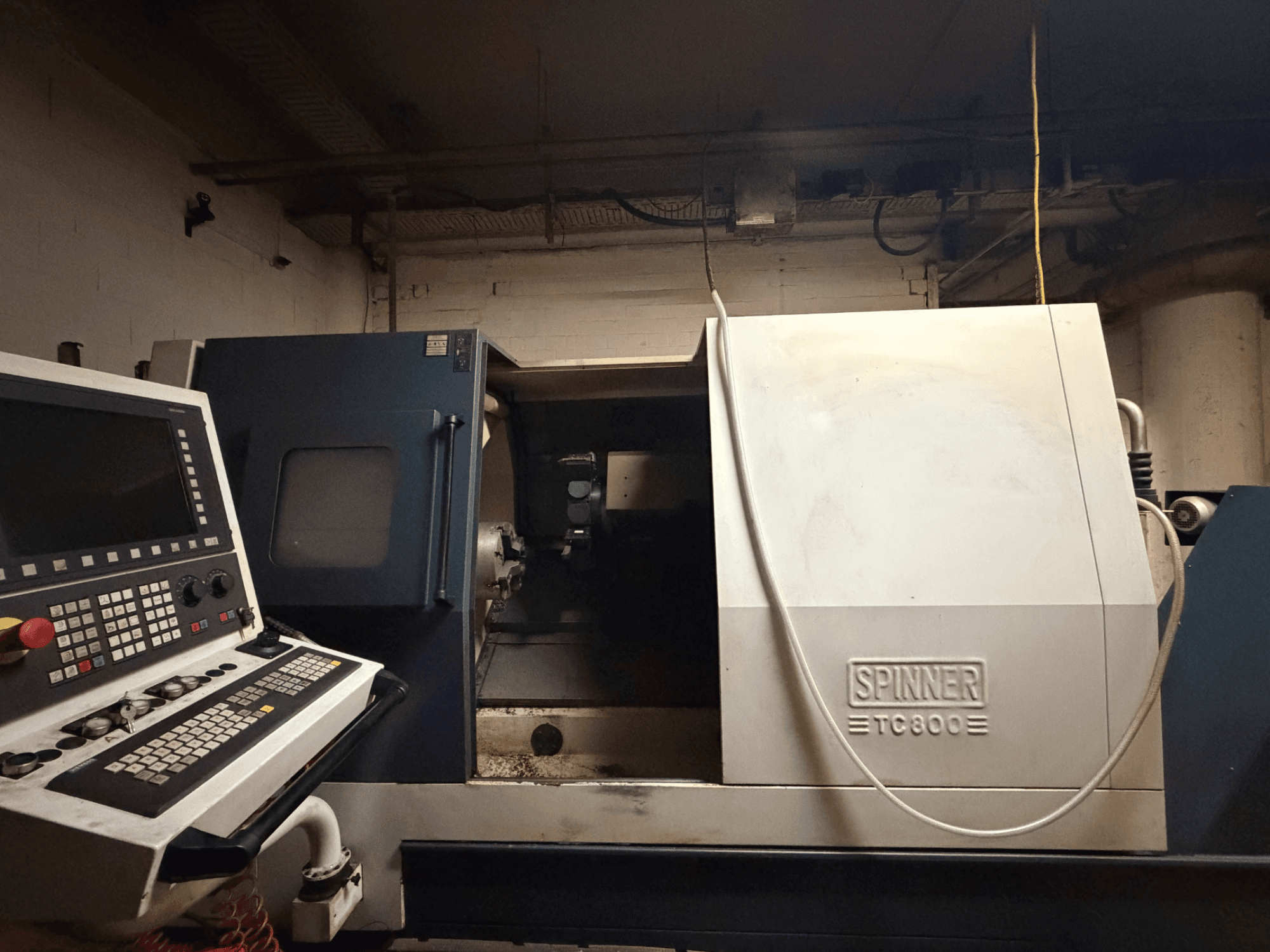 Horizontalni tokarski stroj SPINNER TC800, prednji pogled s vidljivom upravljačkom pločom i blago izloženom unutrašnjosti stroja.