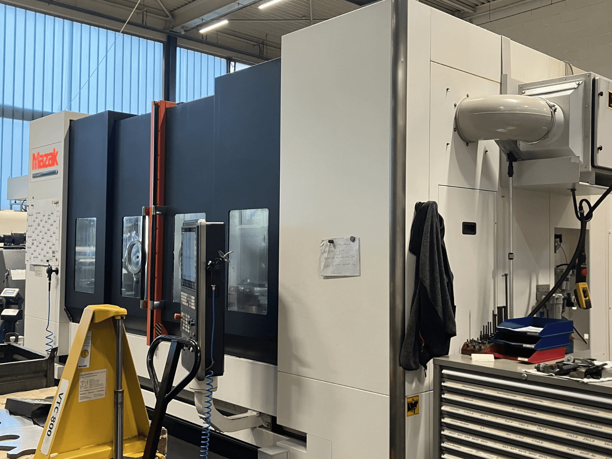 Mazakov CNC stroj gledan sa strane, s prikazom upravljačke ploče i sigurnosnih značajki u radioničkom okruženju.
