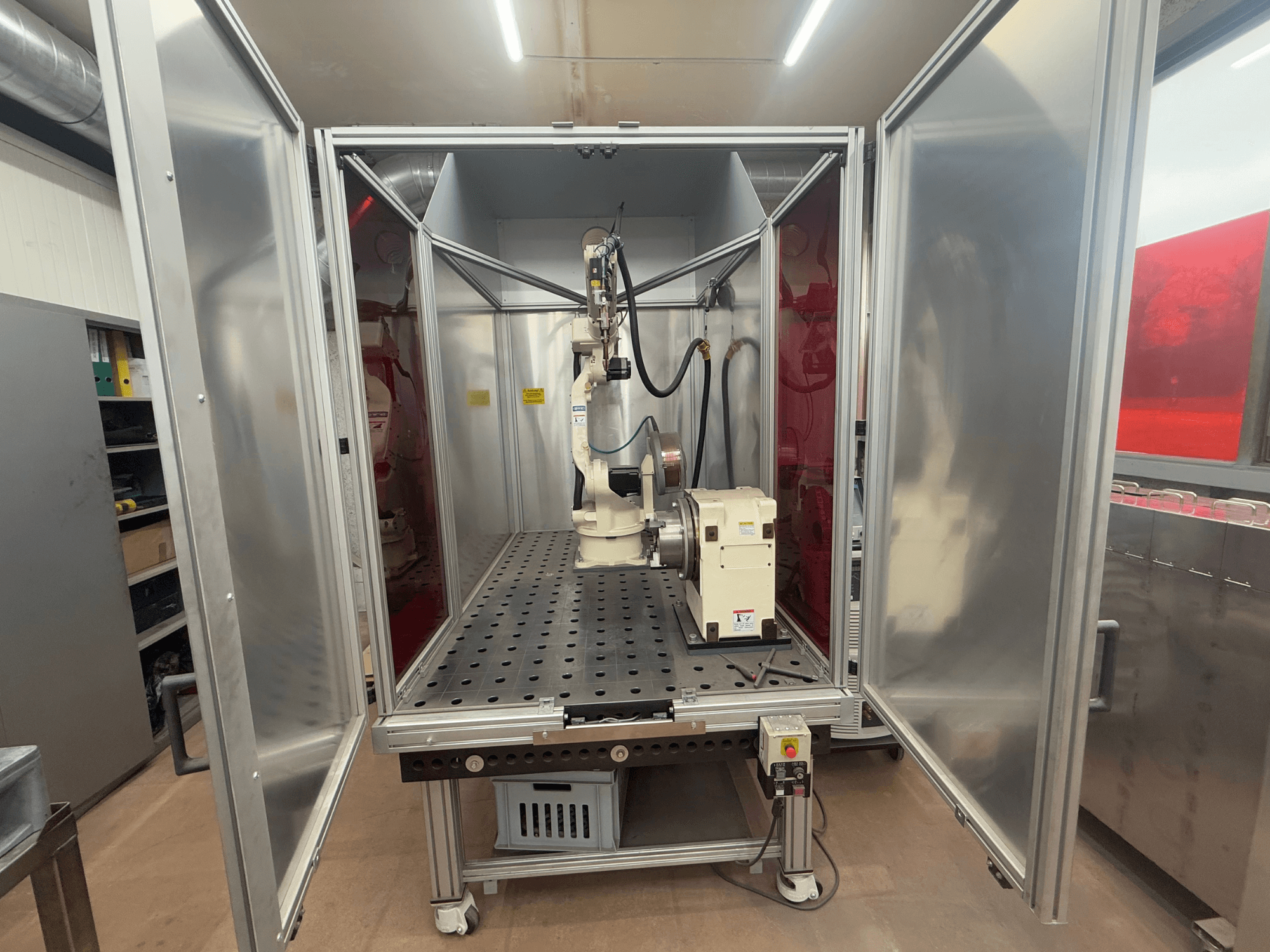 Robot za zavarivanje OTC Daihen EASY ARC V02.04 u metalnom kućištu, gledan sprijeda, s vidljivom zglobnom rukom i upravljačkom pločom.